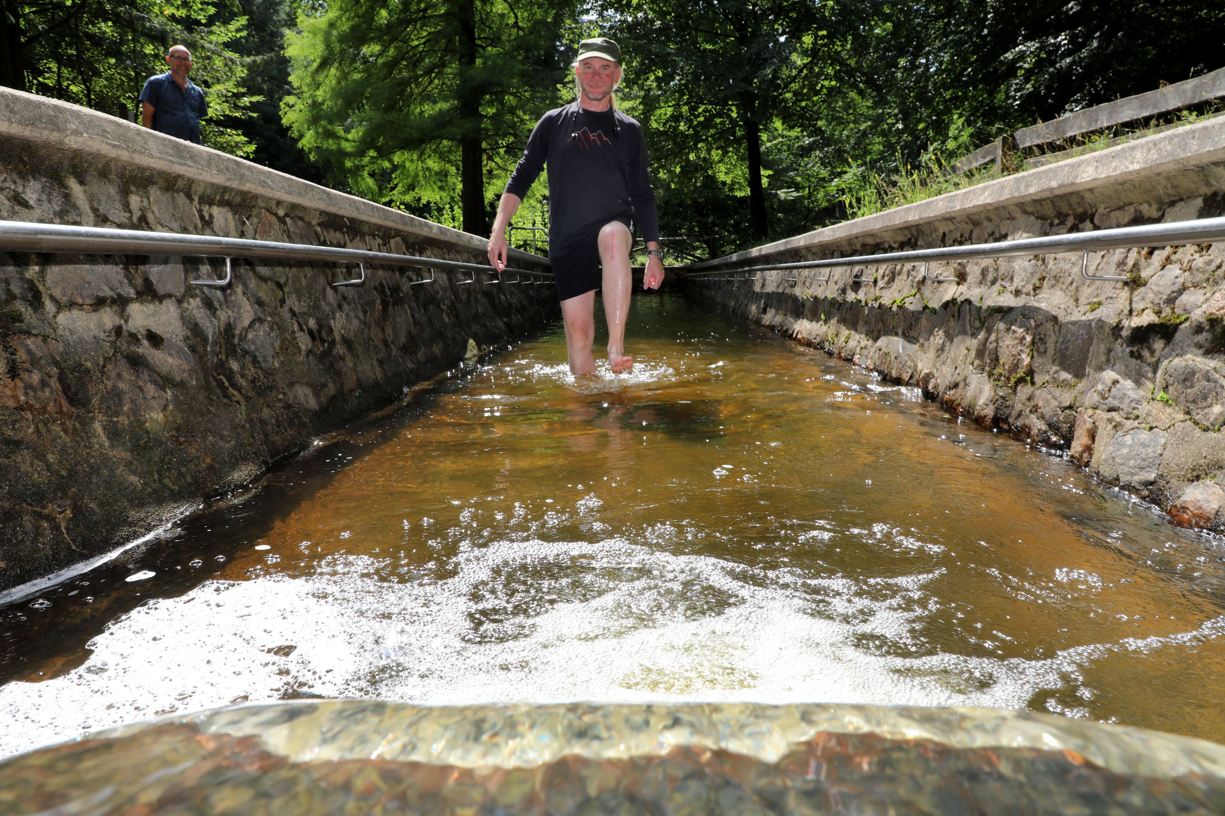 Ein Mann läuft durch eine Wassertretstelle im Königsforst.