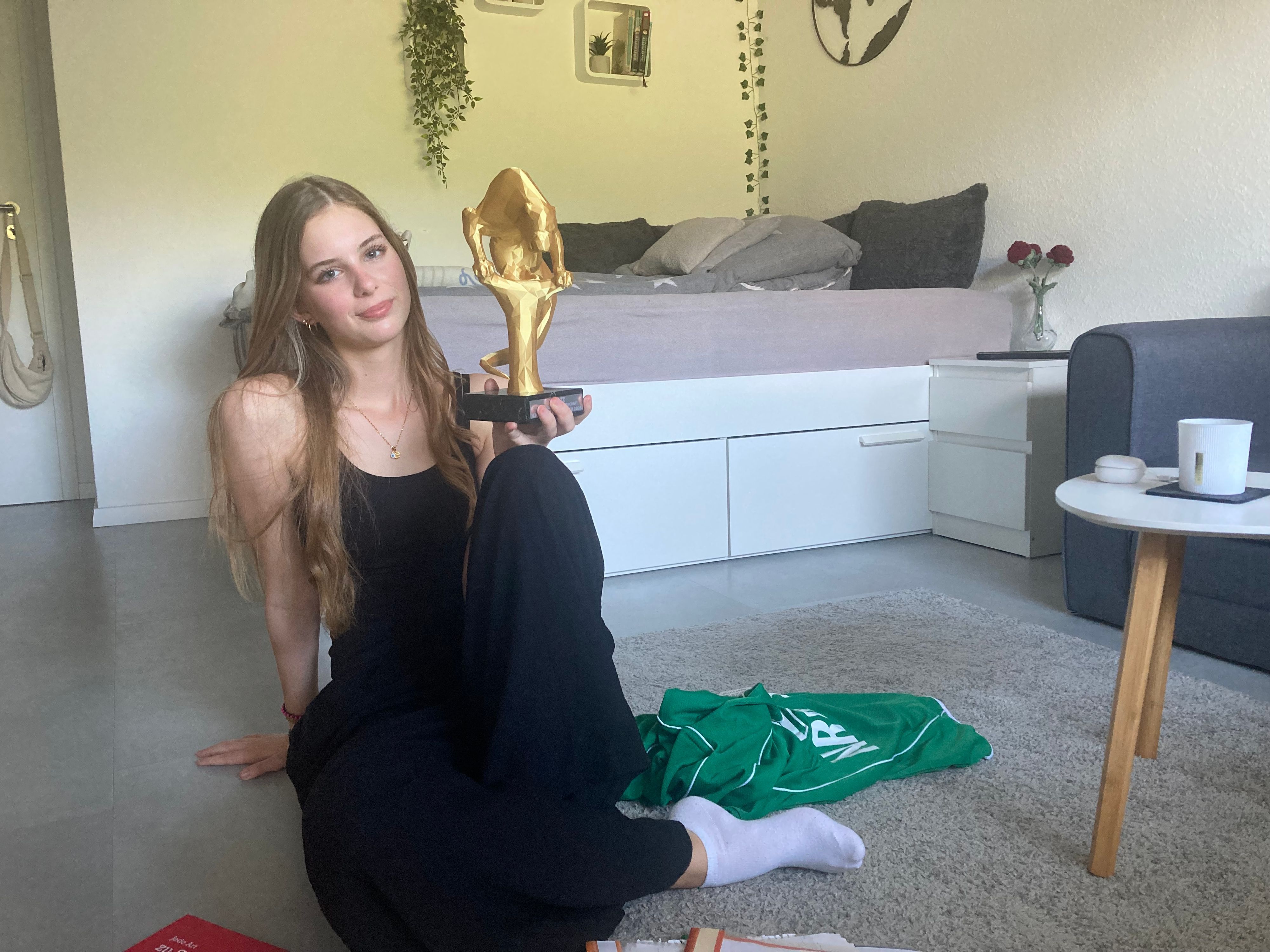 Zu sehen ist die Poetry-Slammerin Hannah Breitbarth mit einem Pokal in der Hand.