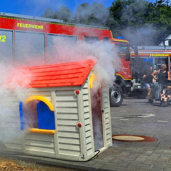 Kinder löschen beim Tag der offenen Tür beim Löschzug Overath ein Spielhaus.