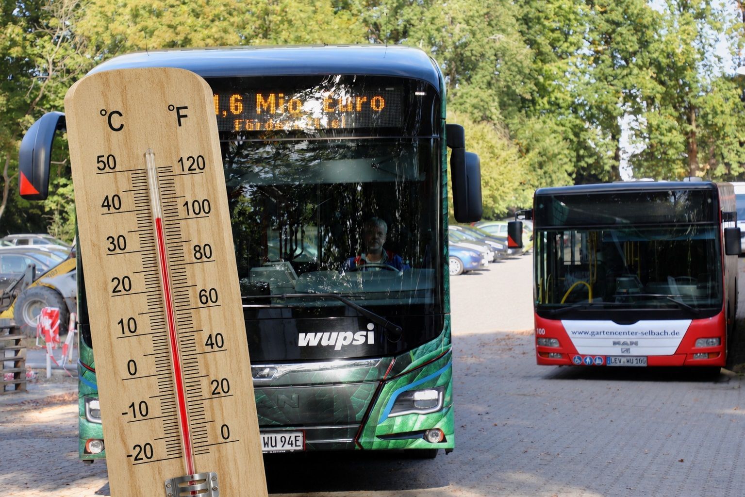 Ein Thermometer vor einem Wupsi-Bus zeigt 36 Grad Celsius an.