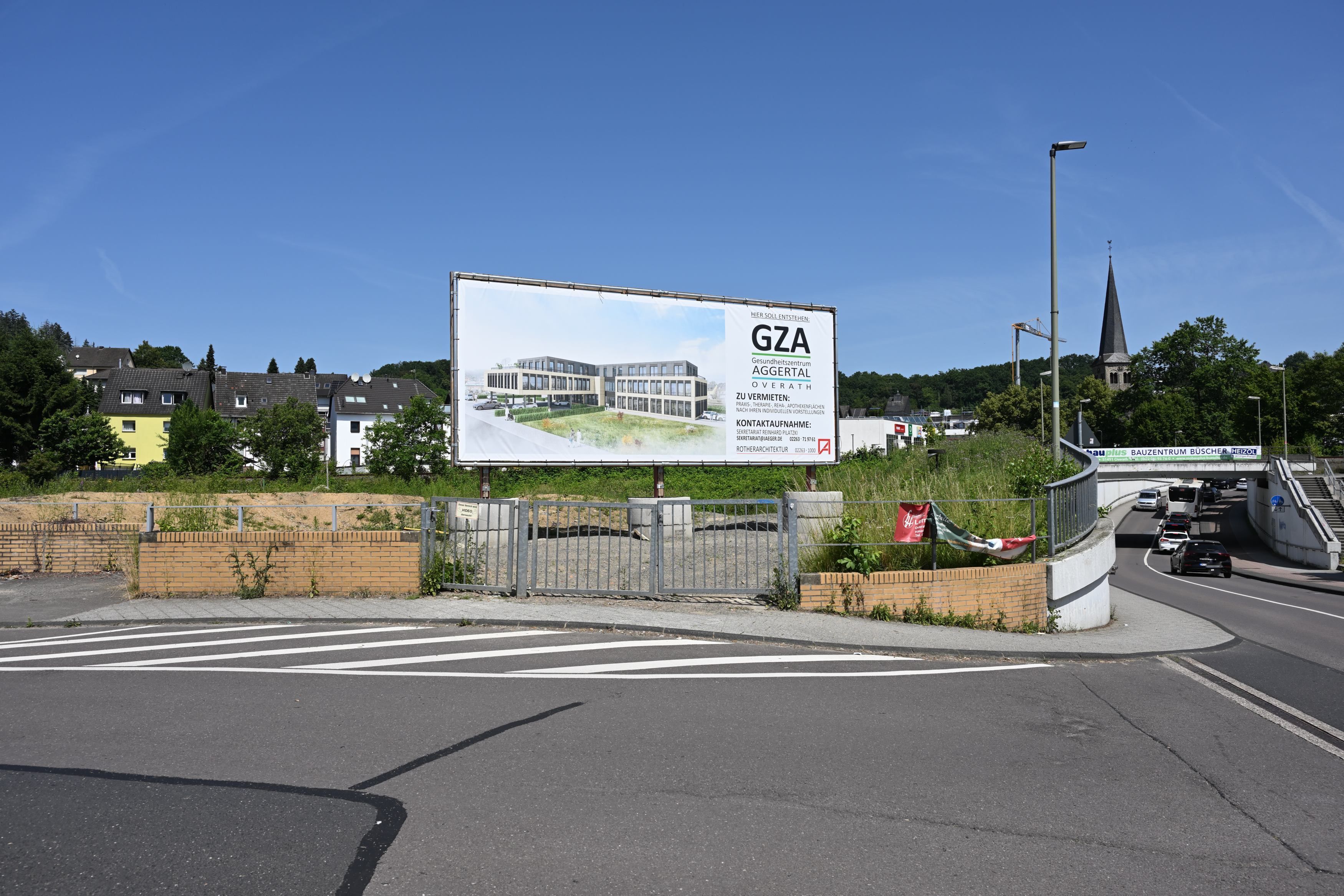 Auf dem Grundstück, wo das Gesundheitszentrum entstehen soll, steht ein Schild mit Visualisierung des Gebäudes.