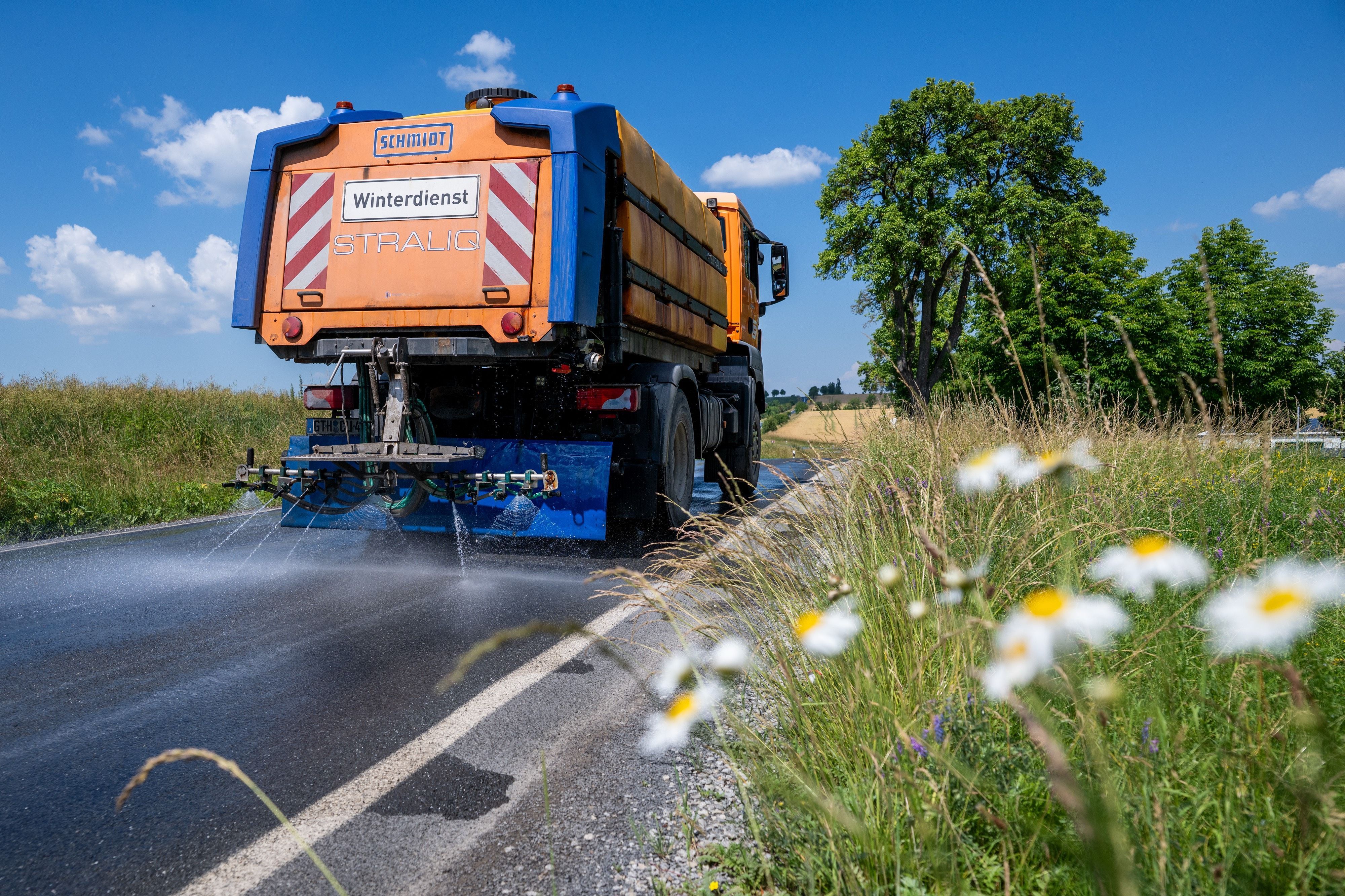Mit einem Winterdienst-Fahrzeug wird die Straße L2038 zwischen Lengefeld und der B247 im Unstrut-Hainich-Kreis bewässert, um diese zu kühlen.