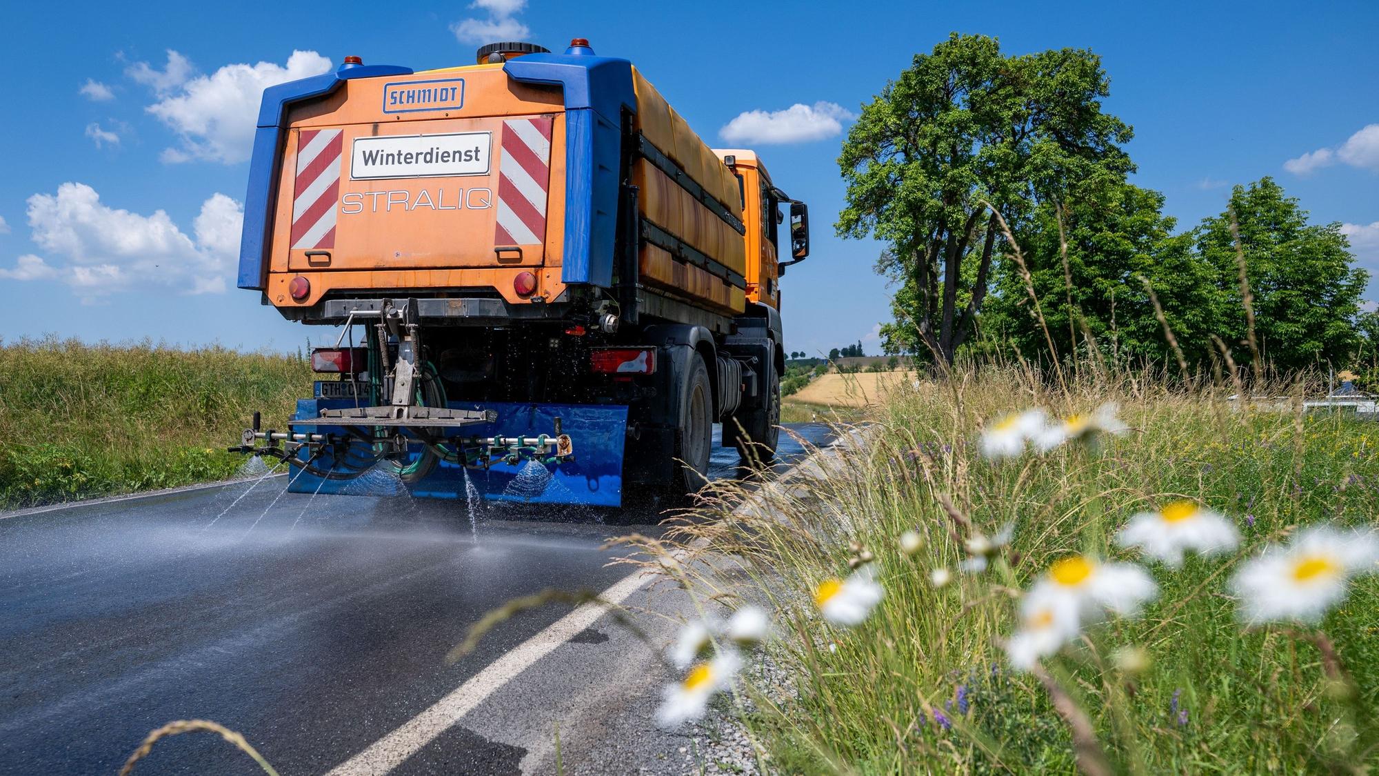 Mit einem Winterdienst-Fahrzeug wird die Straße L2038 zwischen Lengefeld und der B247 im Unstrut-Hainich-Kreis bewässert, um diese zu kühlen.