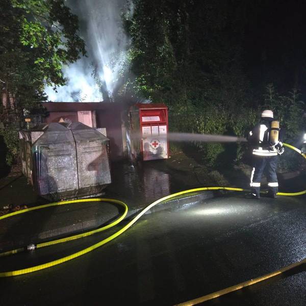 Zu sehen ist ein Feuerwehrmann, der eine brennende Trafostation löscht.