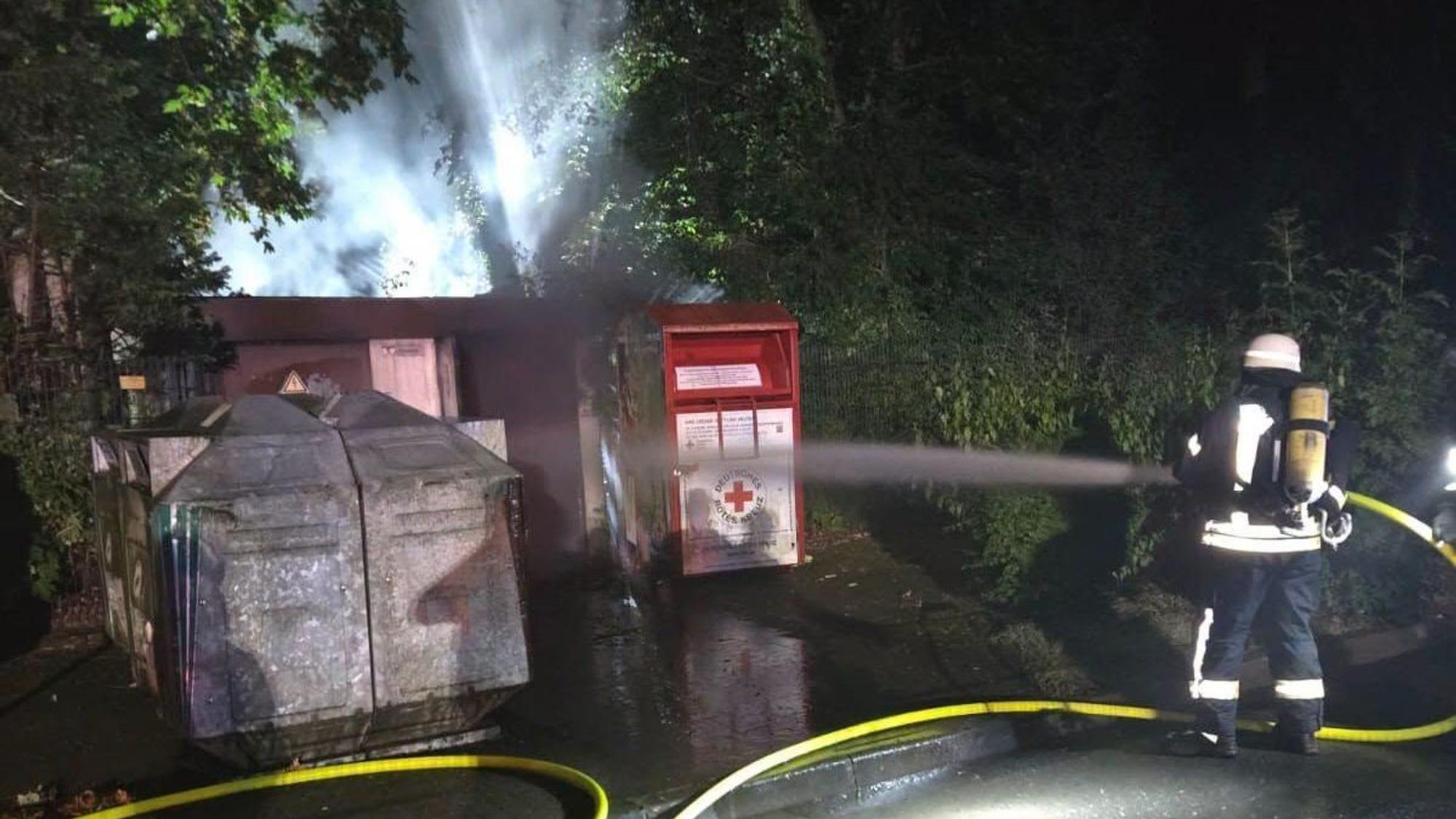 Zu sehen ist ein Feuerwehrmann, der eine brennende Trafostation löscht.