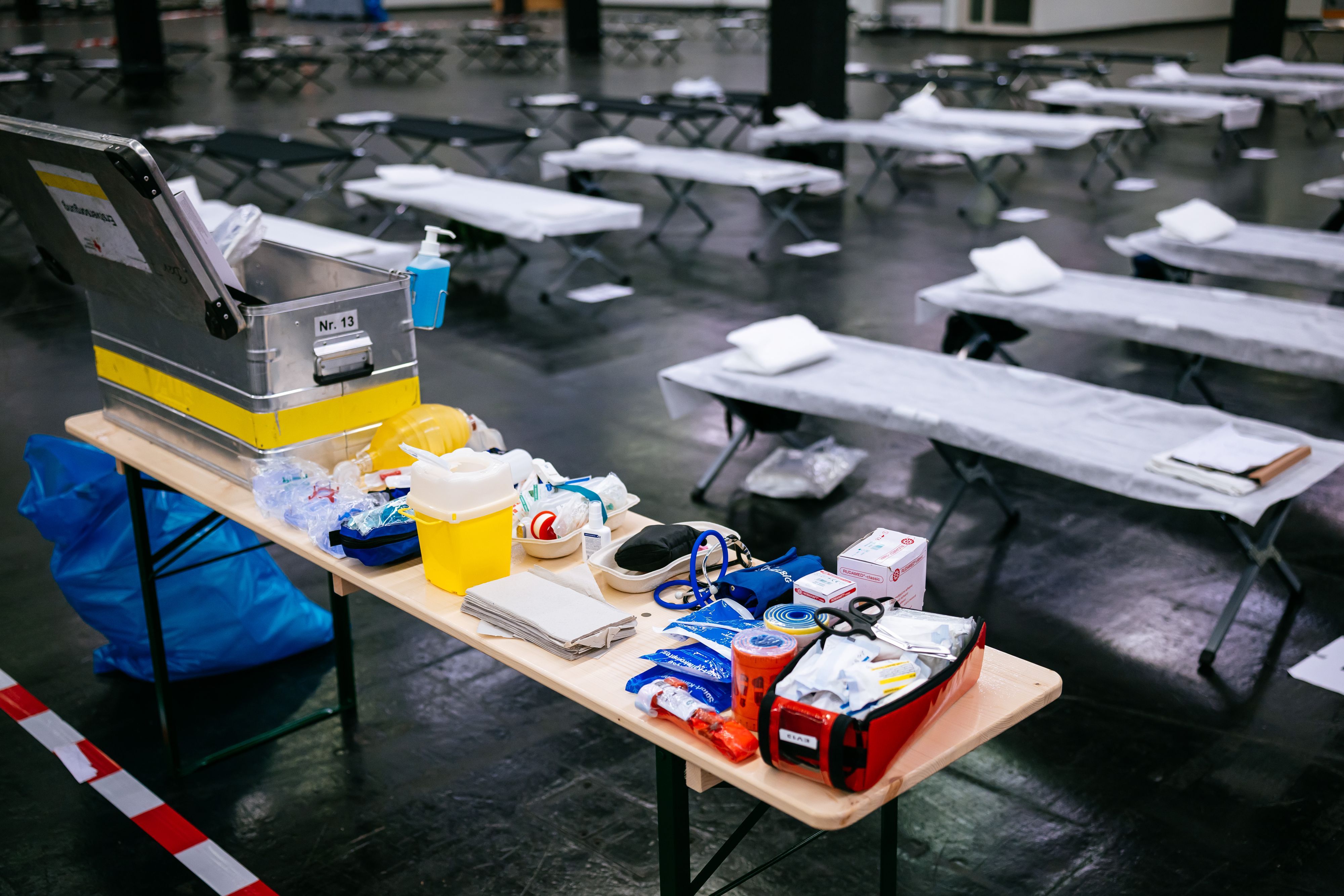 Feldbetten und medizinisches Material stehen im Notfallversorgungszentrum der Feuerwehr Köln in einer gekühlten Messehalle bereit.