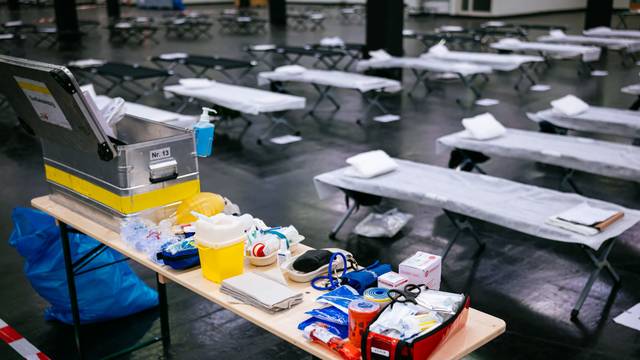 Feldbetten und medizinisches Material stehen im Notfallversorgungszentrum der Feuerwehr Köln in einer gekühlten Messehalle bereit.