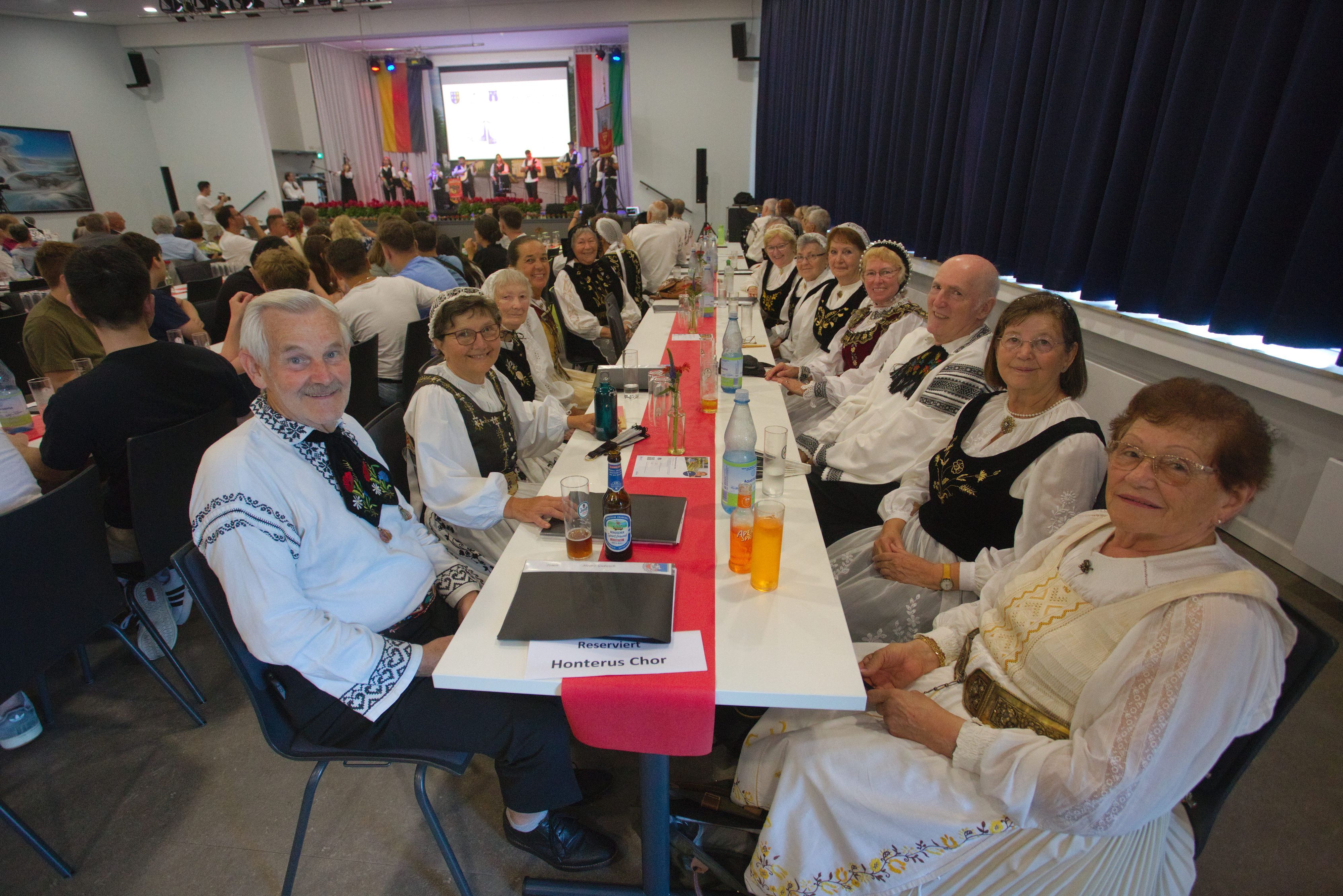 Leute in Tracht sitzen an einem langen Tisch.