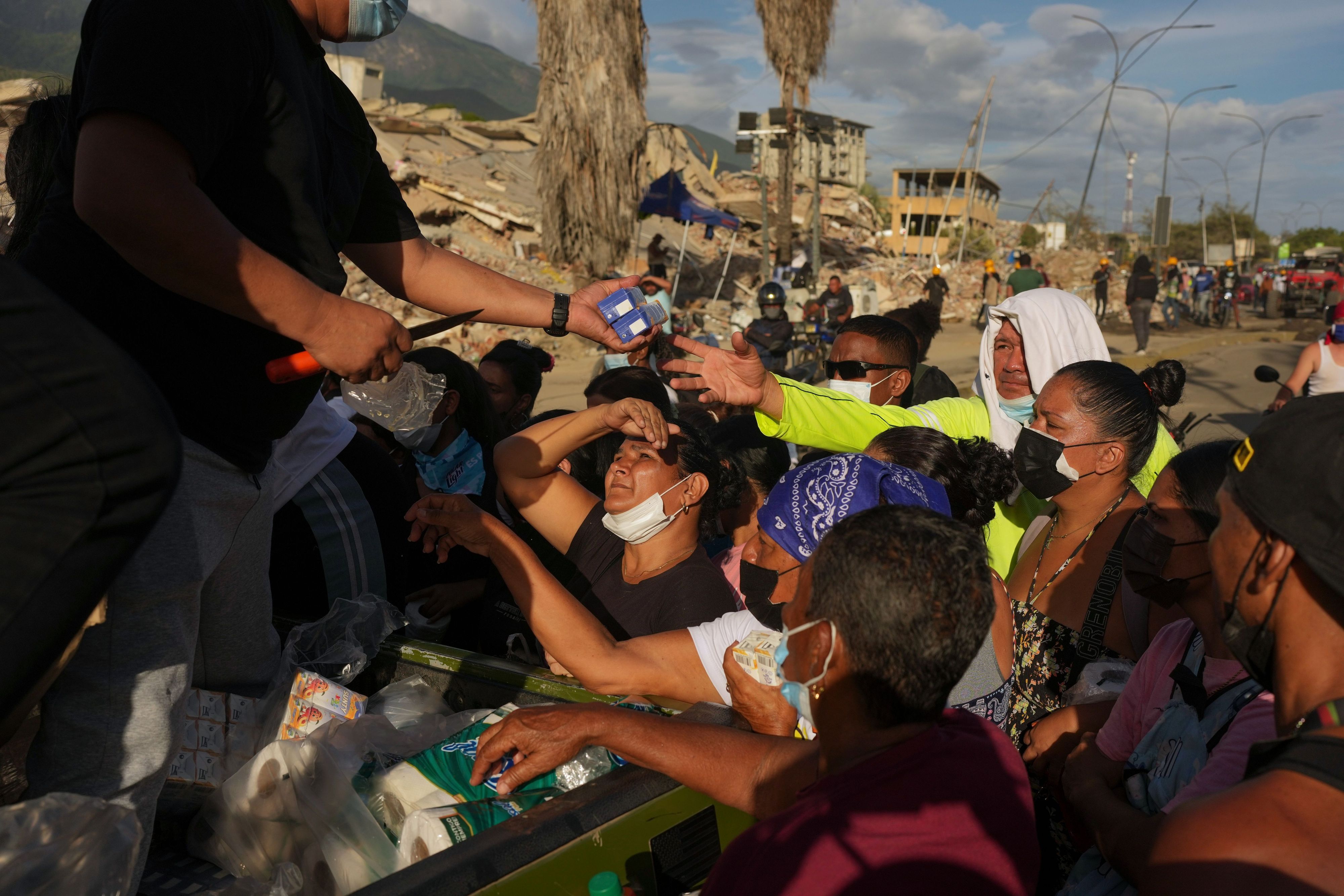 Von den Erdbeben betroffene Menschen stehen in La Guaira für Lebensmittel Schlange.
