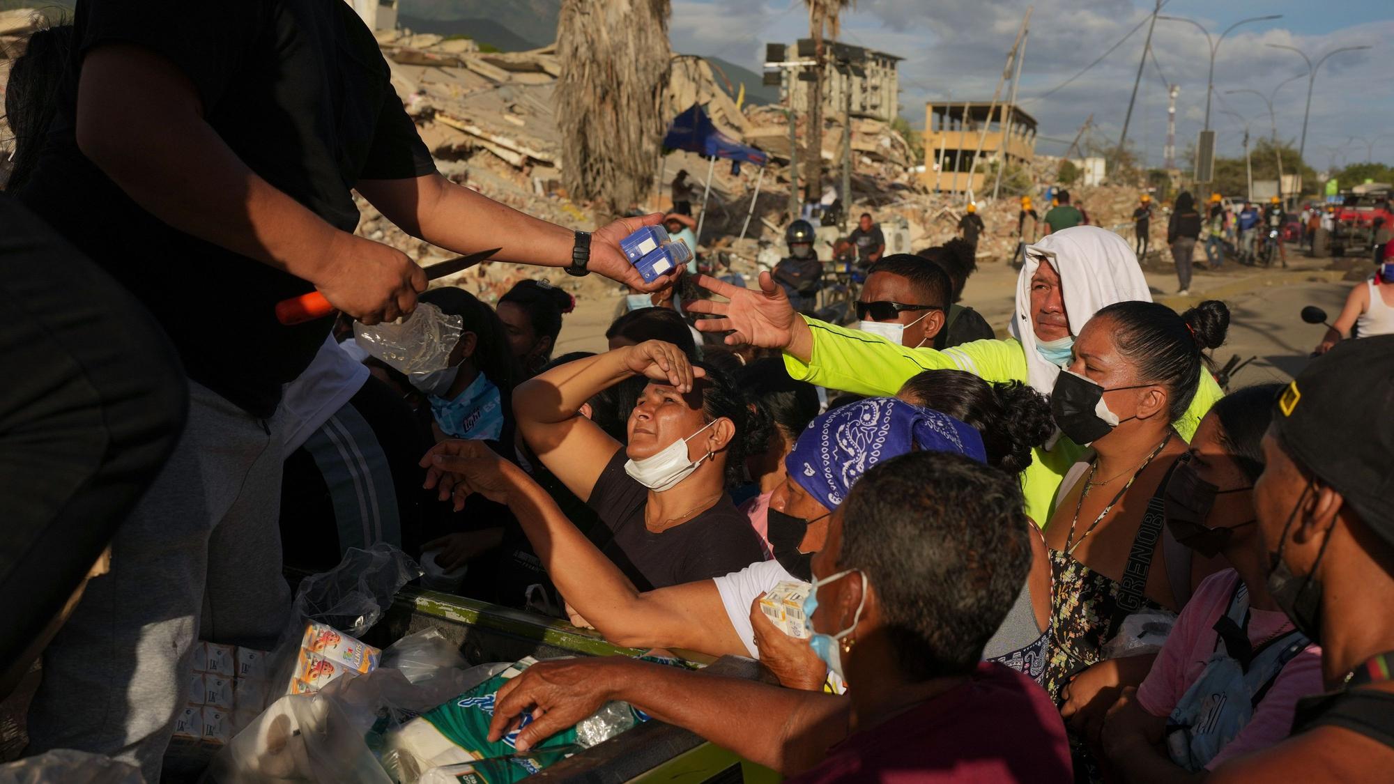 Von den Erdbeben betroffene Menschen stehen in La Guaira für Lebensmittel Schlange.