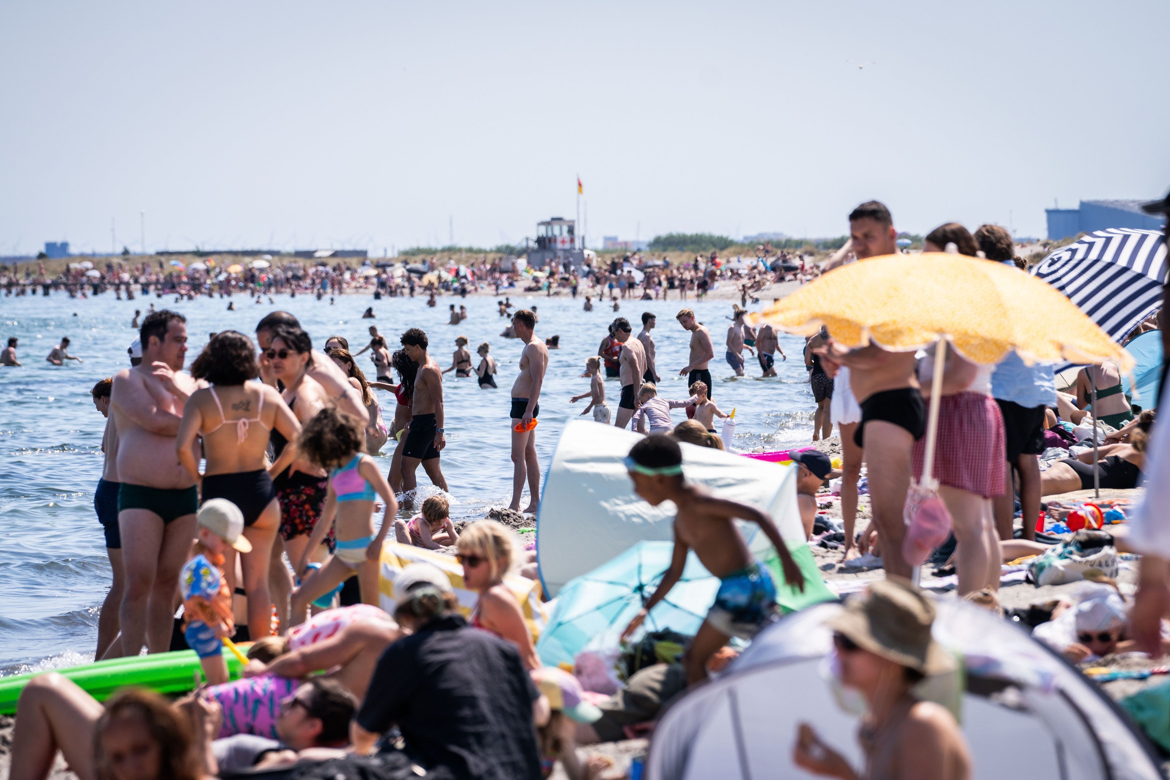 Dänemark, Kopenhagen: Menschen suchen am Amager-Strand Abkühlung im und am Wasser.