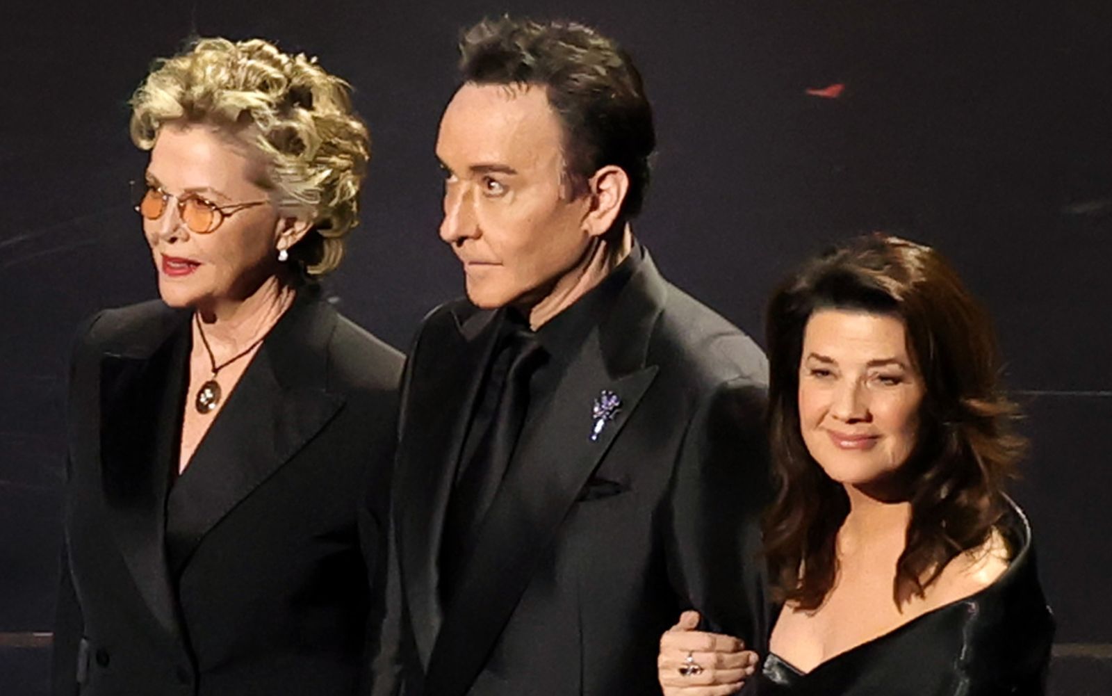 Einen seiner seltenen öffentlichen Auftritte hatte John Cusack bei der Oscar-Verleihung 2026, als er mit zahlreichen Kolleginnen (im Bild Annette Bening, links und Daphne Zuniga, rechts) und Kollegen dem verstorbenen Regisseur Rob Reiner gedachte. (Bild: Kevin Winter/Getty Images)