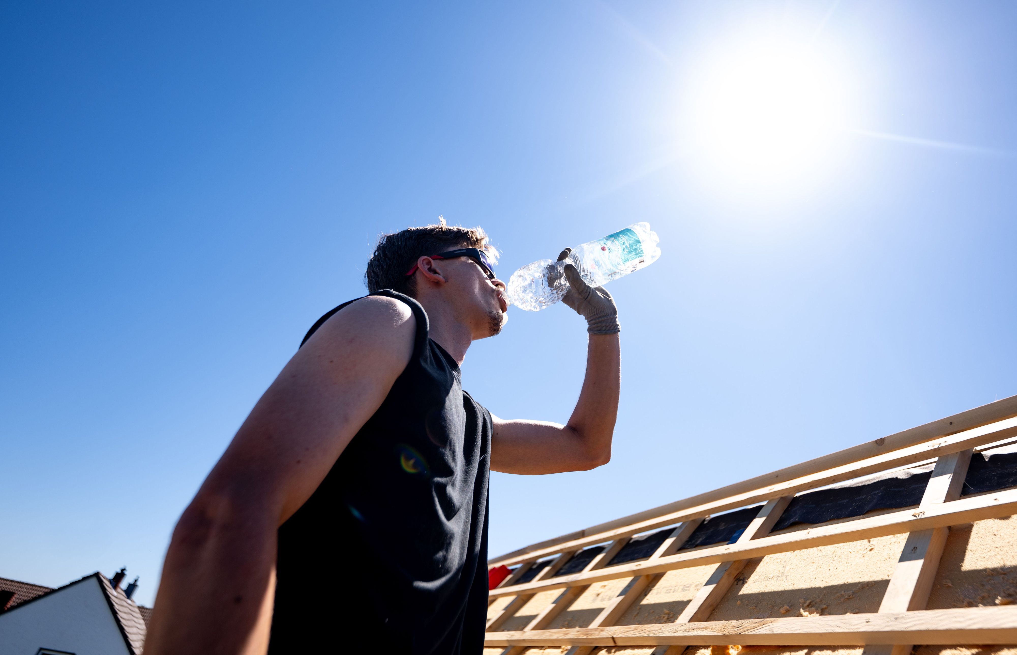 Ein Mann trinkt Wasser in der sengenden Sonne bei über 30 Grad. (Archivbild)