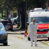Einsatzkräfte und die Spurensicherung stehen auf einer Straße in Stade. Hier sind fünf Menschen durch Schüsse gestorben.