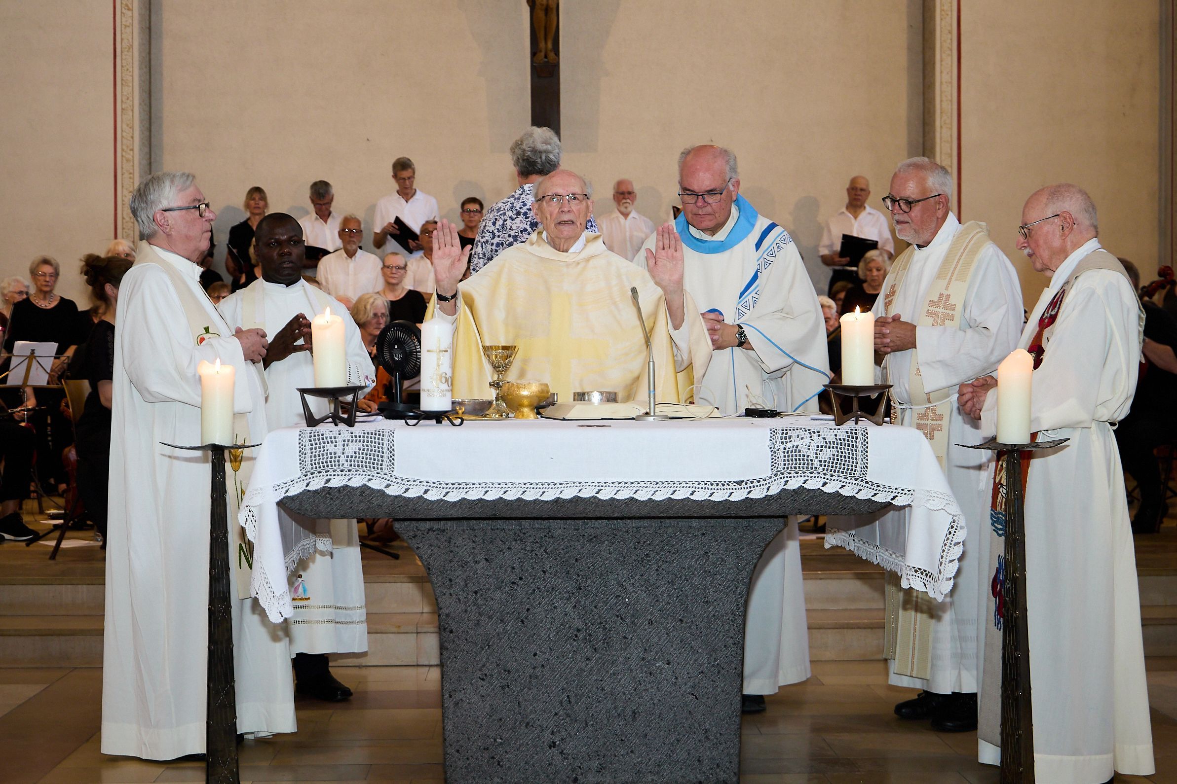 Pastor Felix Dörpinghaus (Mitte) steht mit vier weiteren katholischen Geistlichen in liturgischen Gewänddern an einem Altar.