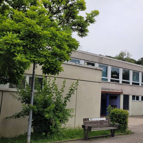 Ein weißes Flachdachgebäude, vier Stockwerke, daran angebaut eins mit zwei Stockwerken.