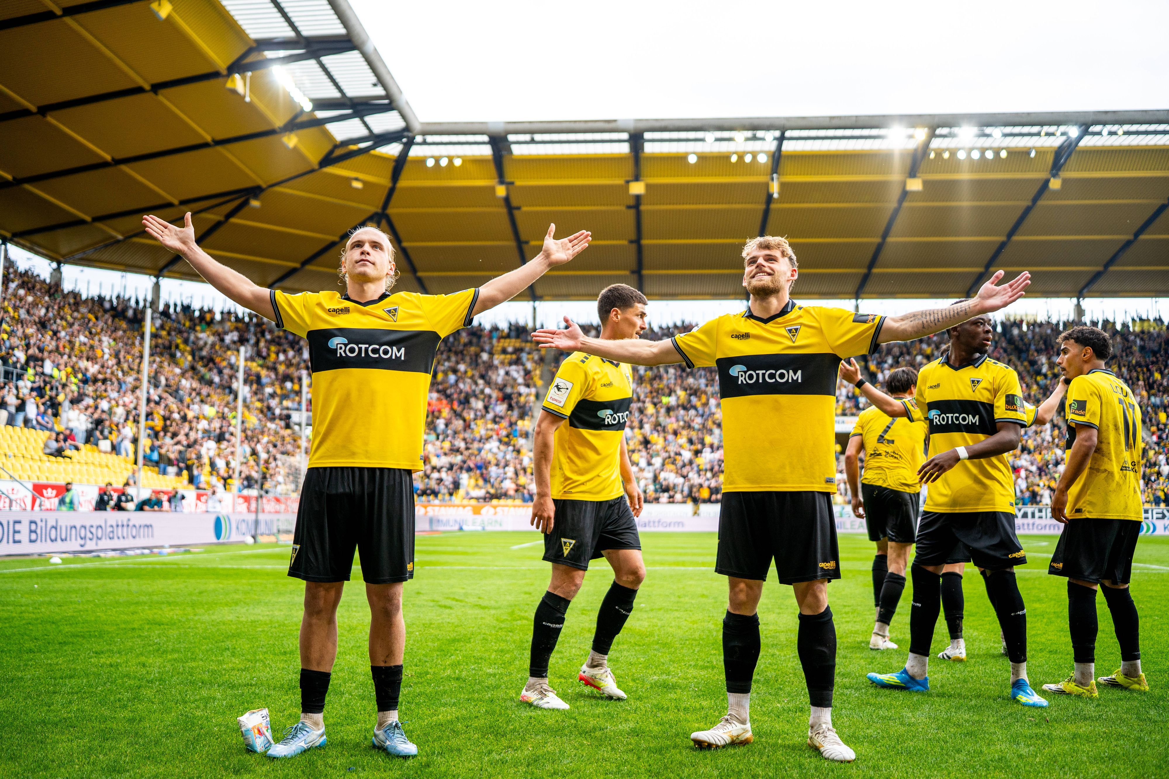 Ein Mann trägt ein gelb-schwarzes Alemannia Aachen-Trikot.