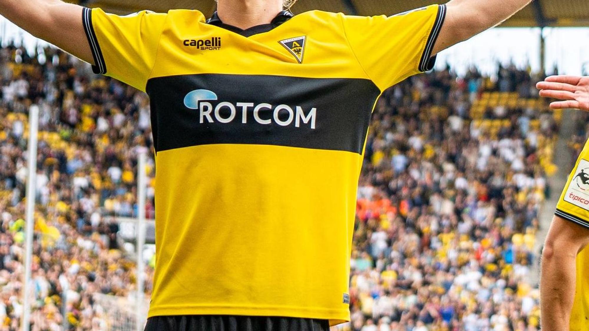 Ein Mann trägt ein gelb-schwarzes Alemannia Aachen-Trikot.