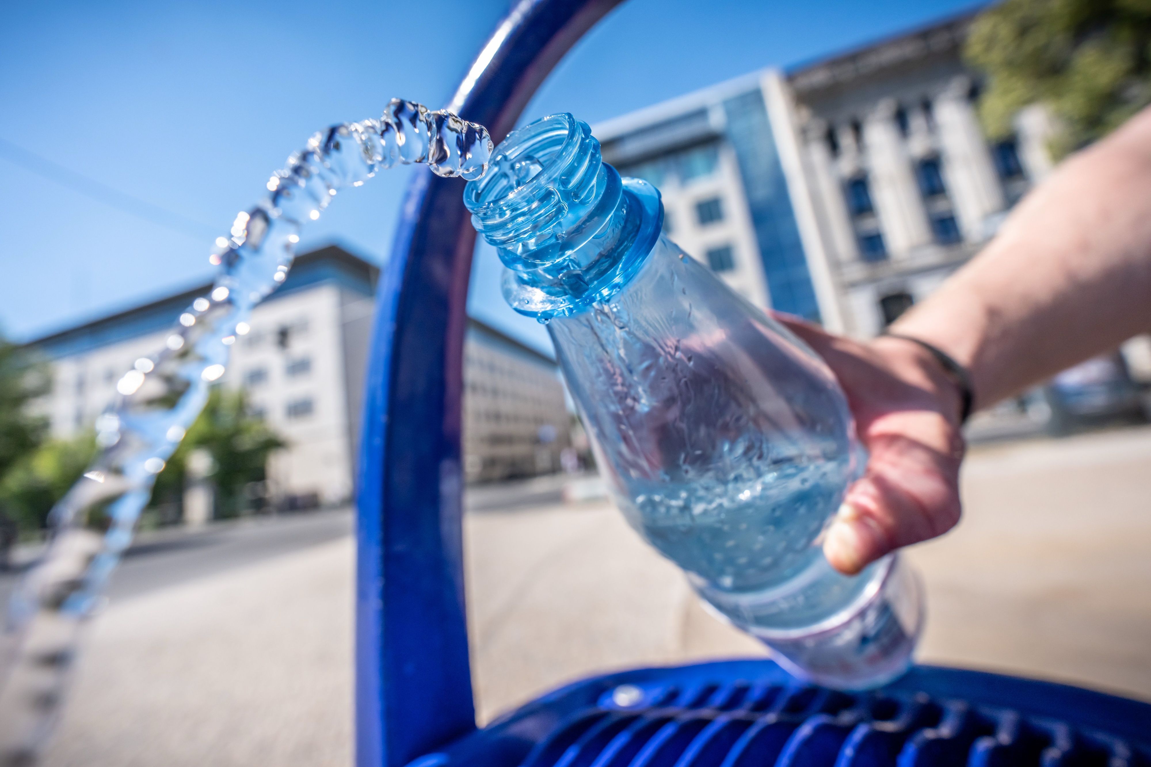Ein Mann füllt seine Wasserflasche an einem öffentlichen Wasserspender.