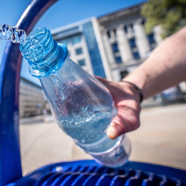 Ein Mann füllt seine Wasserflasche an einem öffentlichen Wasserspender.