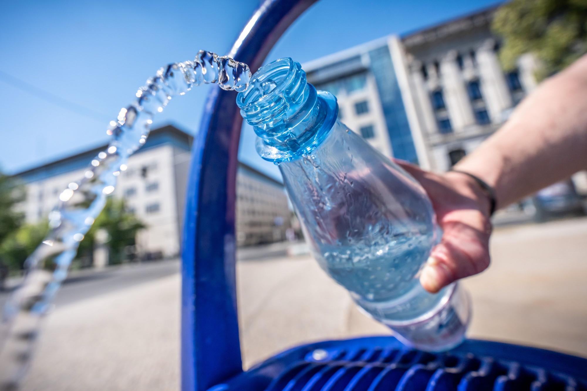 Ein Mann füllt seine Wasserflasche an einem öffentlichen Wasserspender.