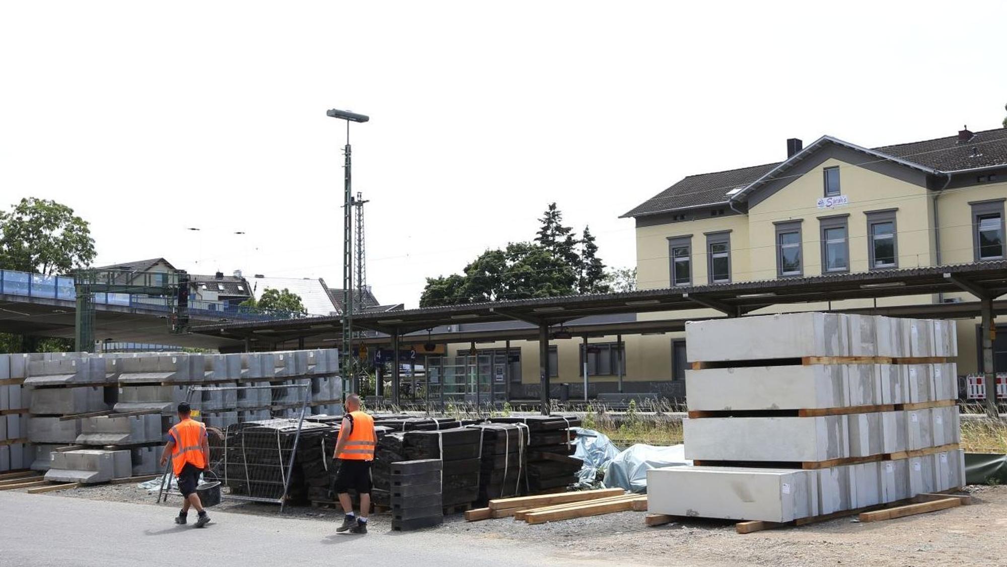Bauteile auf einer Betonfläche im Hintergrund ein Bahnhof.