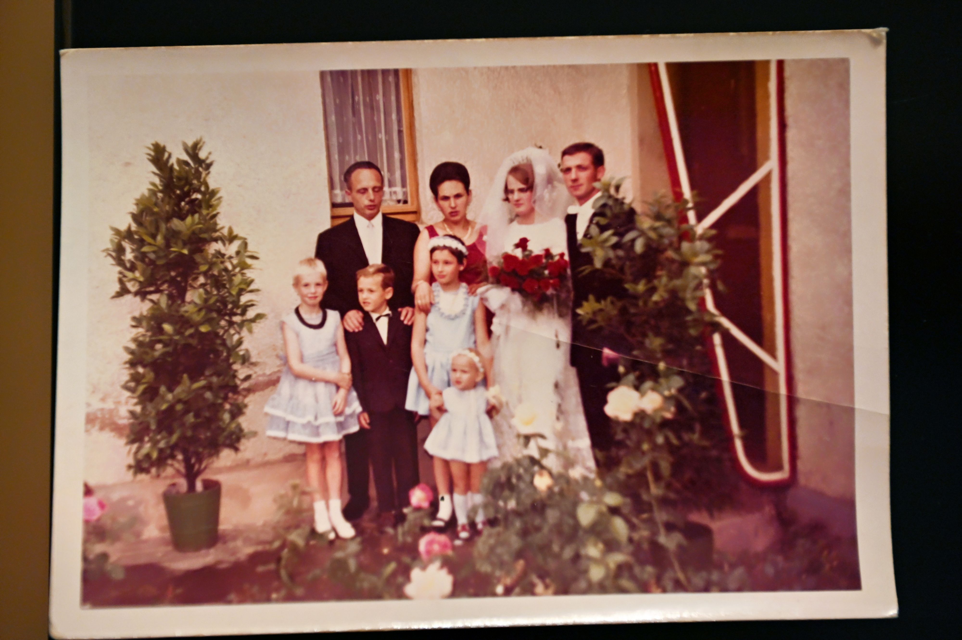 Das Fotos aus dem Jahr 1964 zeigt ein Hochzeitspaar mit einigen Gästen.
