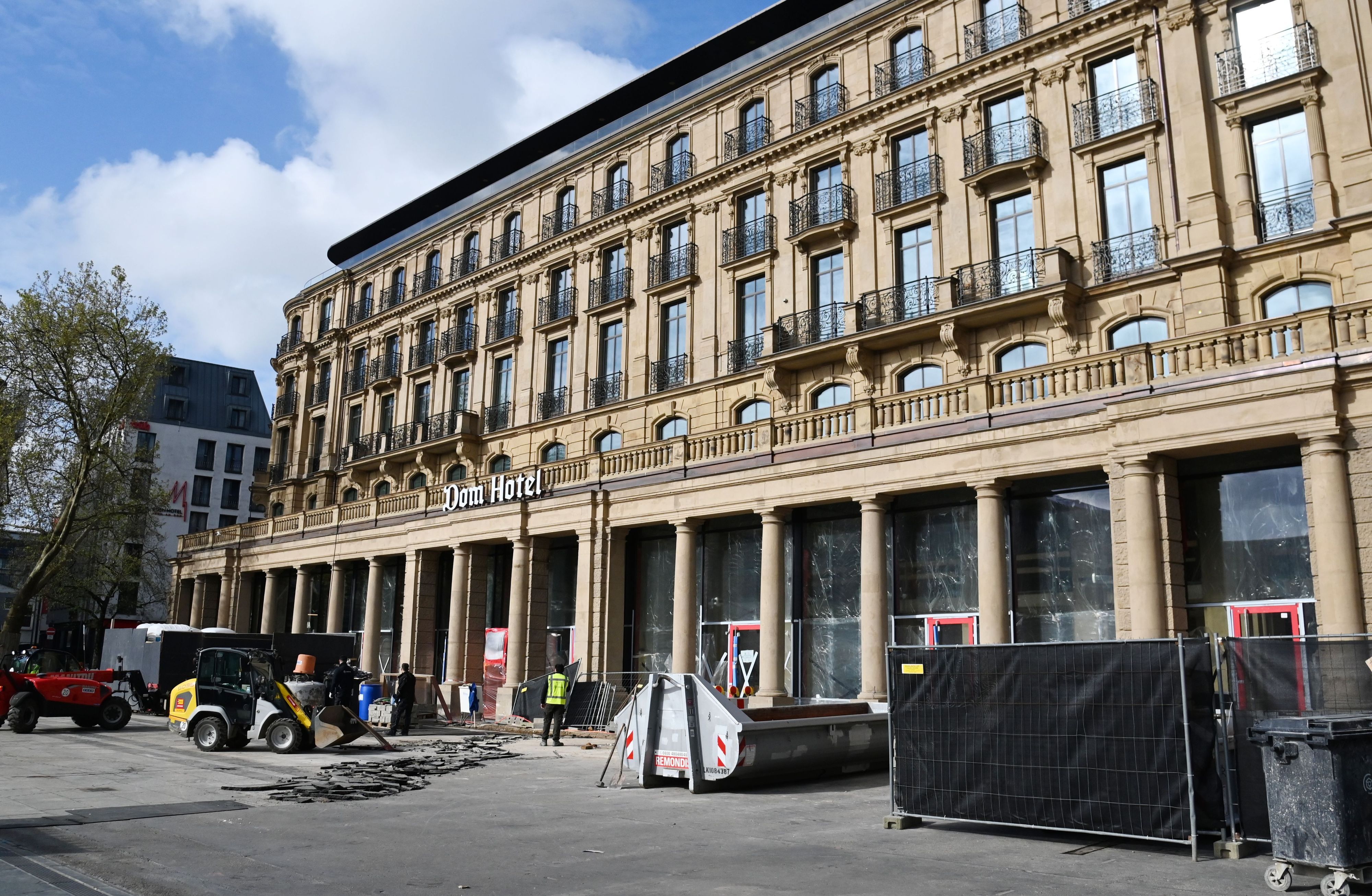 Vor dem Dom-Hotel wird ein Bodenbelag entfernt und der Bauzaun weiter abgebaut.