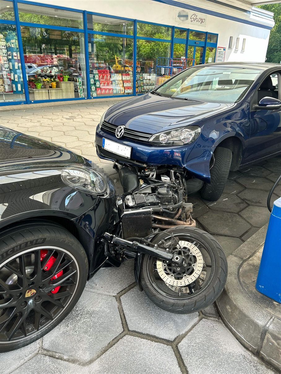 Bei einem Unfall auf dem Gelände der Jaeger-Tankstelle in Wiehl-Alperbrück wurden mehrere Fahrzeuge beschädigt. Durch die Wucht des Aufpralls wurde ein Motorrad in die Front eines schwarzen Porsche gedrückt.
