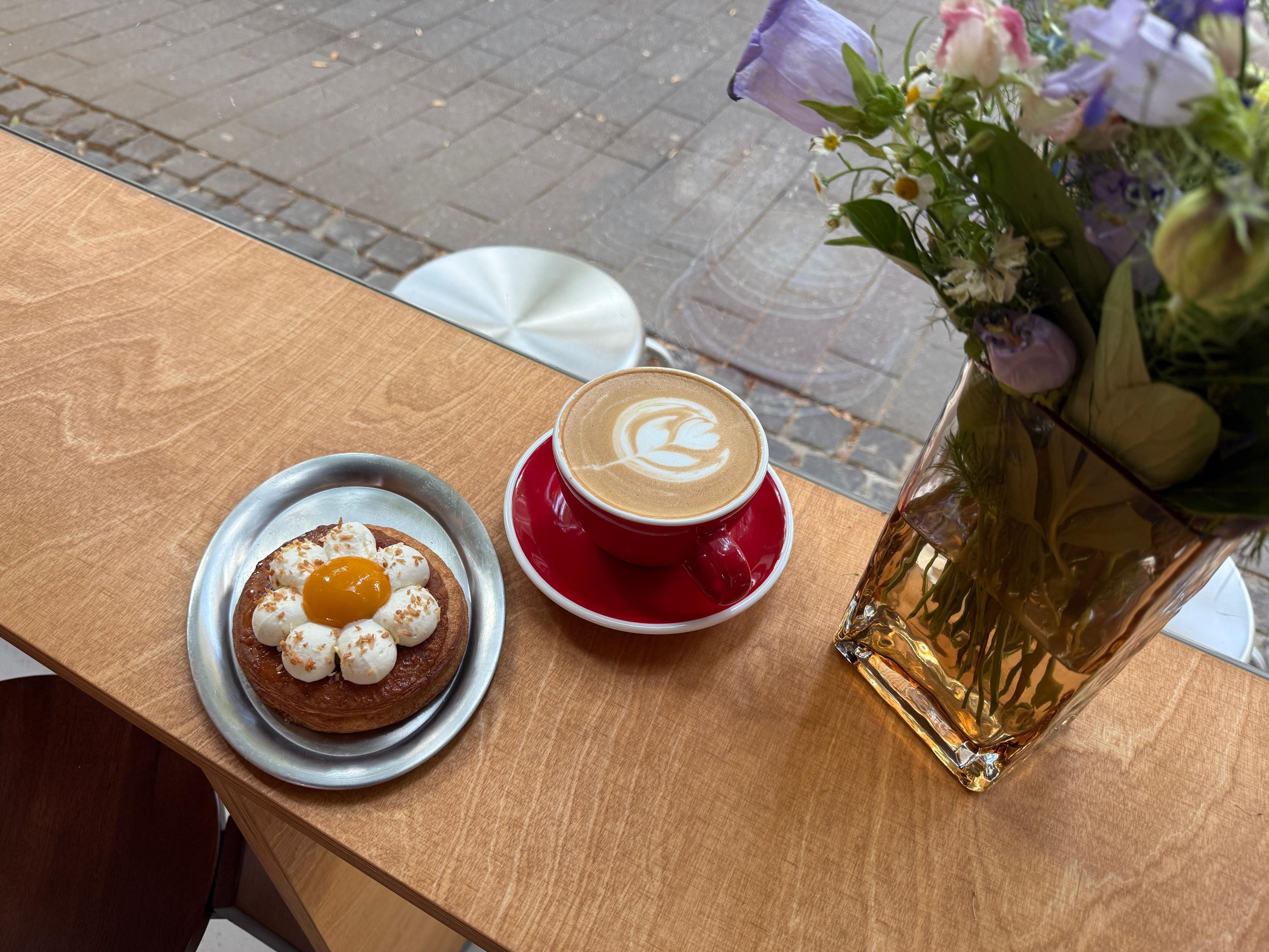 Leckeres Gebäck und ein Cappuccino mit hübscher Latte Art bei „Crop Coffee“.