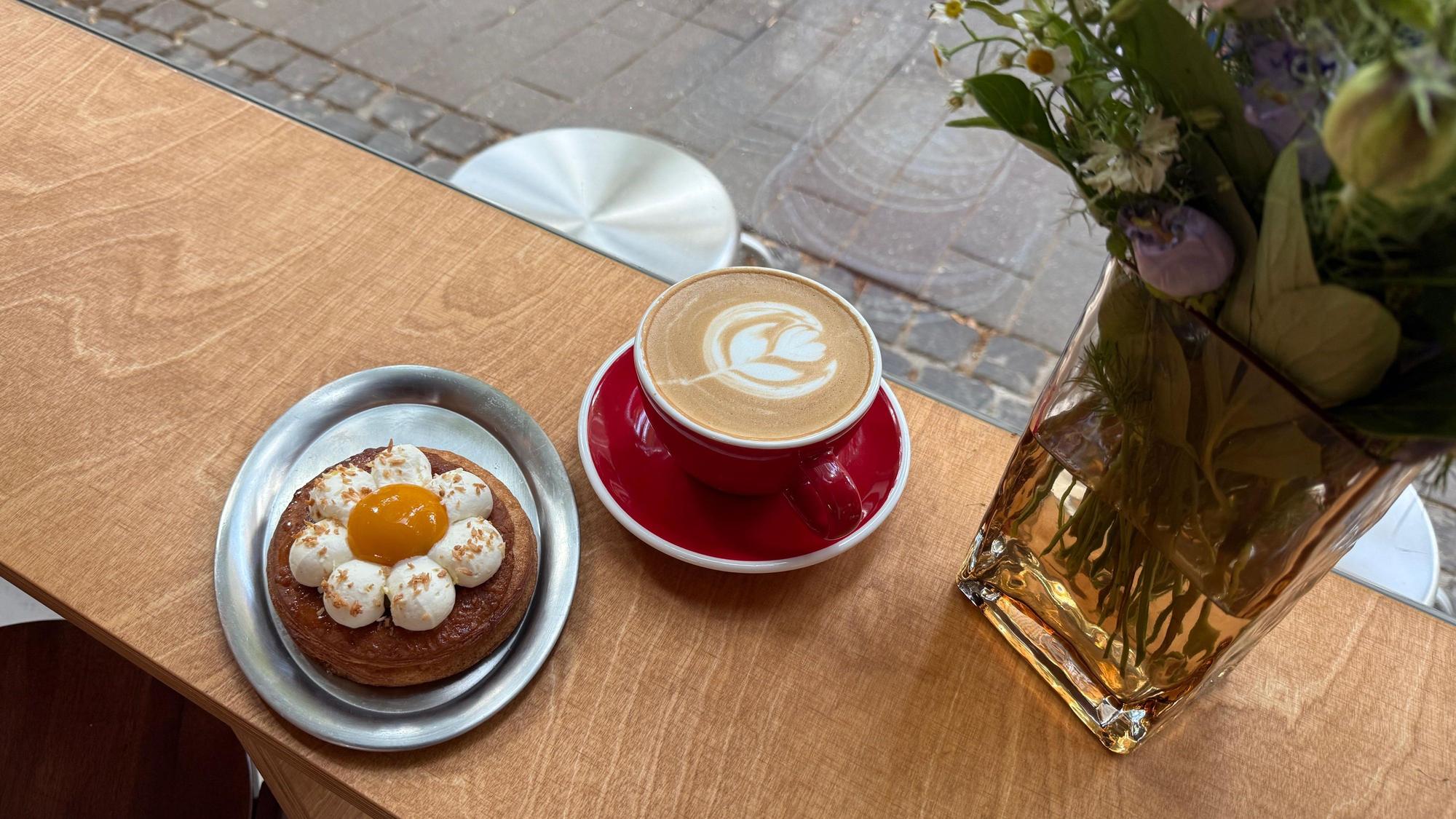 Leckeres Gebäck und ein Cappuccino mit hübscher Latte Art bei „Crop Coffee“.