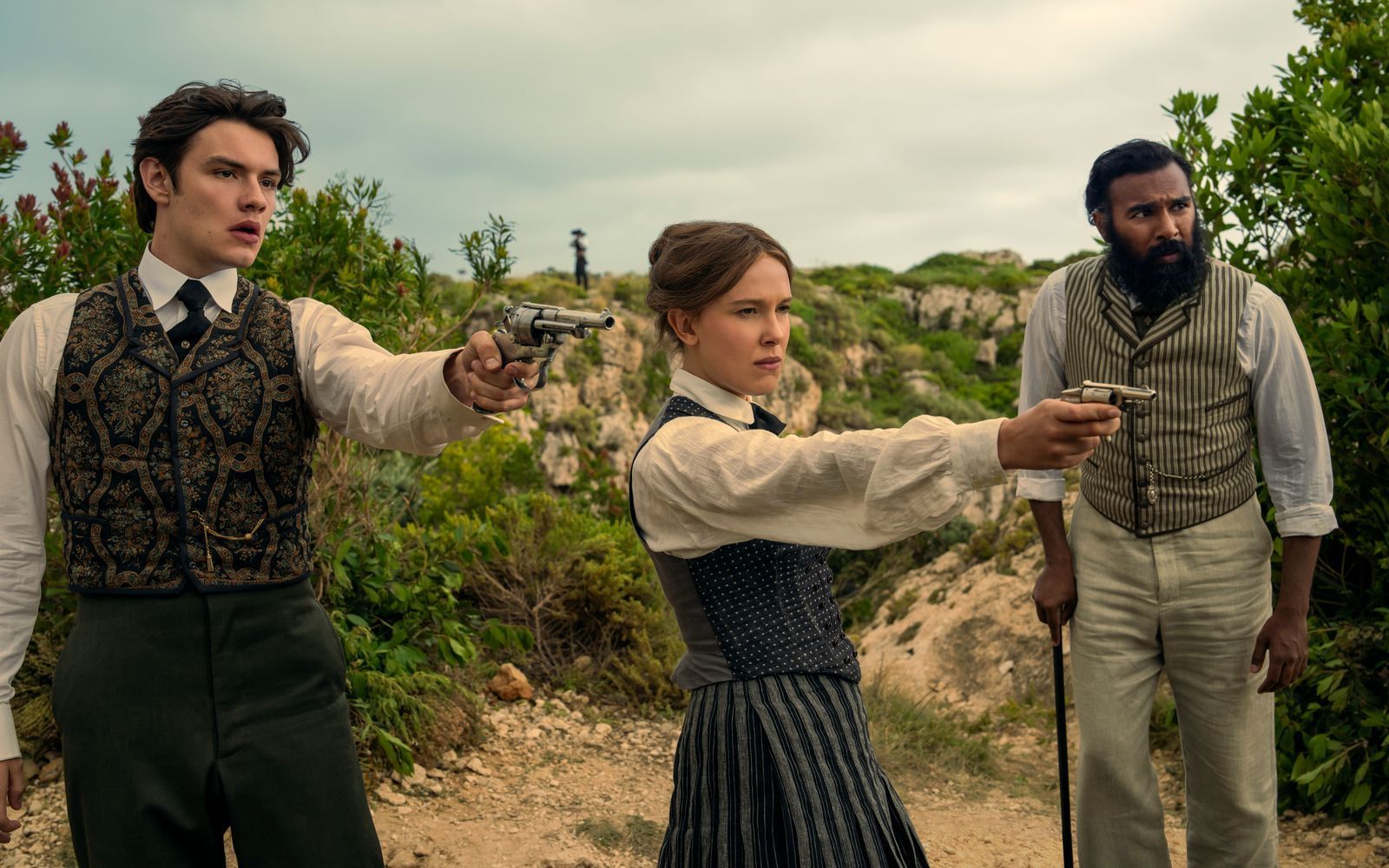 Tewkesbury (Louis Partridge, links), Enola Holmes (Millie Bobby Brown) und Dr. Watson (Himesh Patel) lassen nichts unversucht, um Sherlok zu befreien.  (Bild: John Wilson/Netflix 2026)