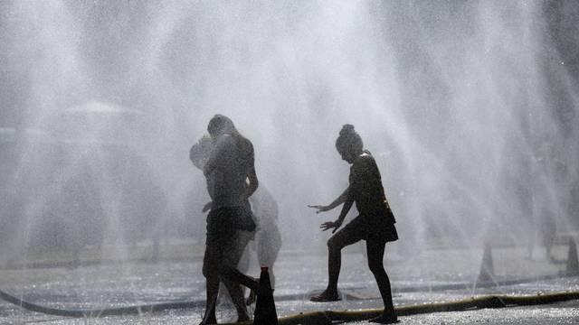 Passanten erfrischen sich an Wasserfontänen