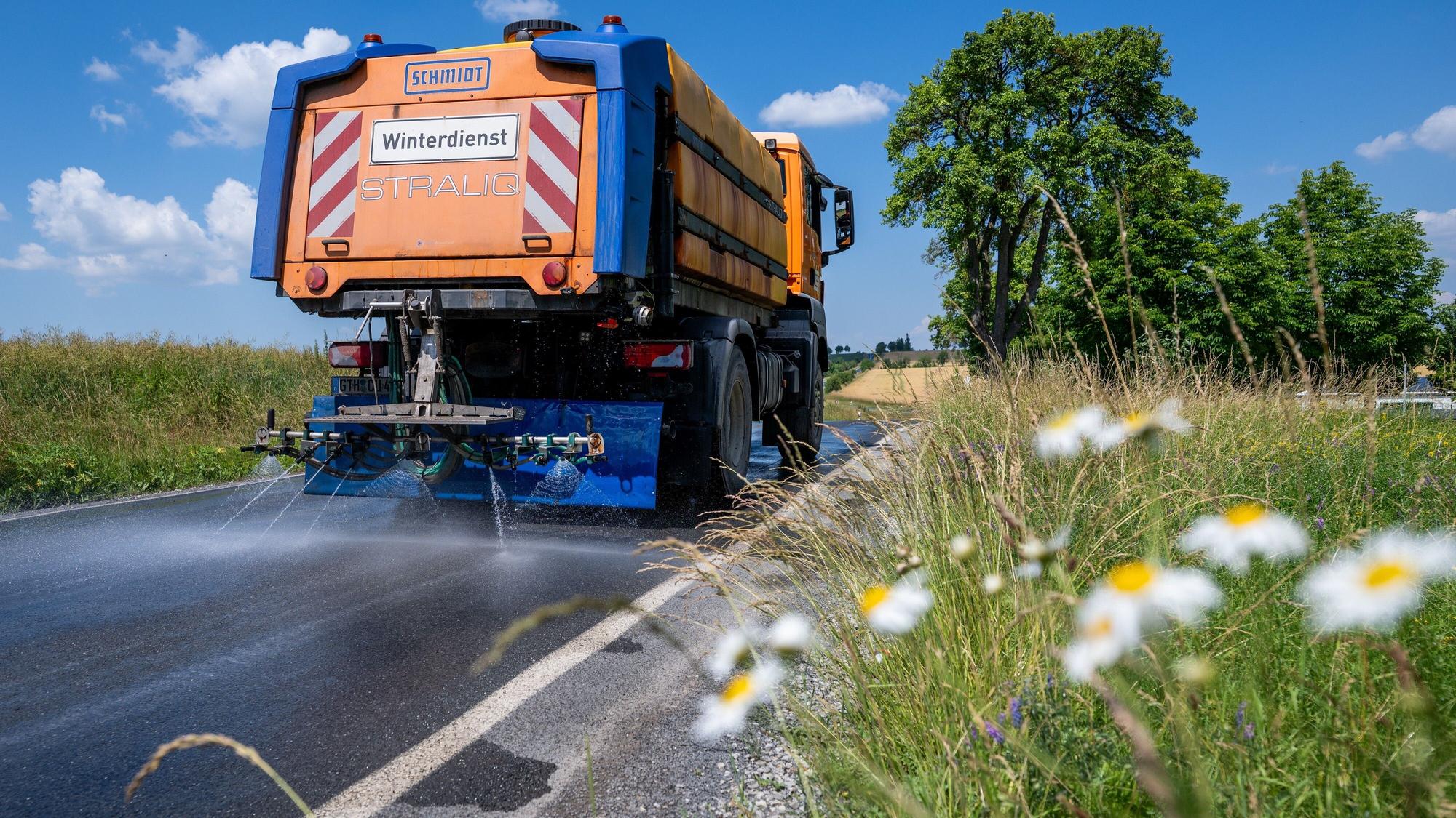 Mit einem Winterdienst-Fahrzeug wird die Straße L2038 zwischen Lengefeld und der B247 im Unstrut-Hainich-Kreis bewässert, um diese zu kühlen.