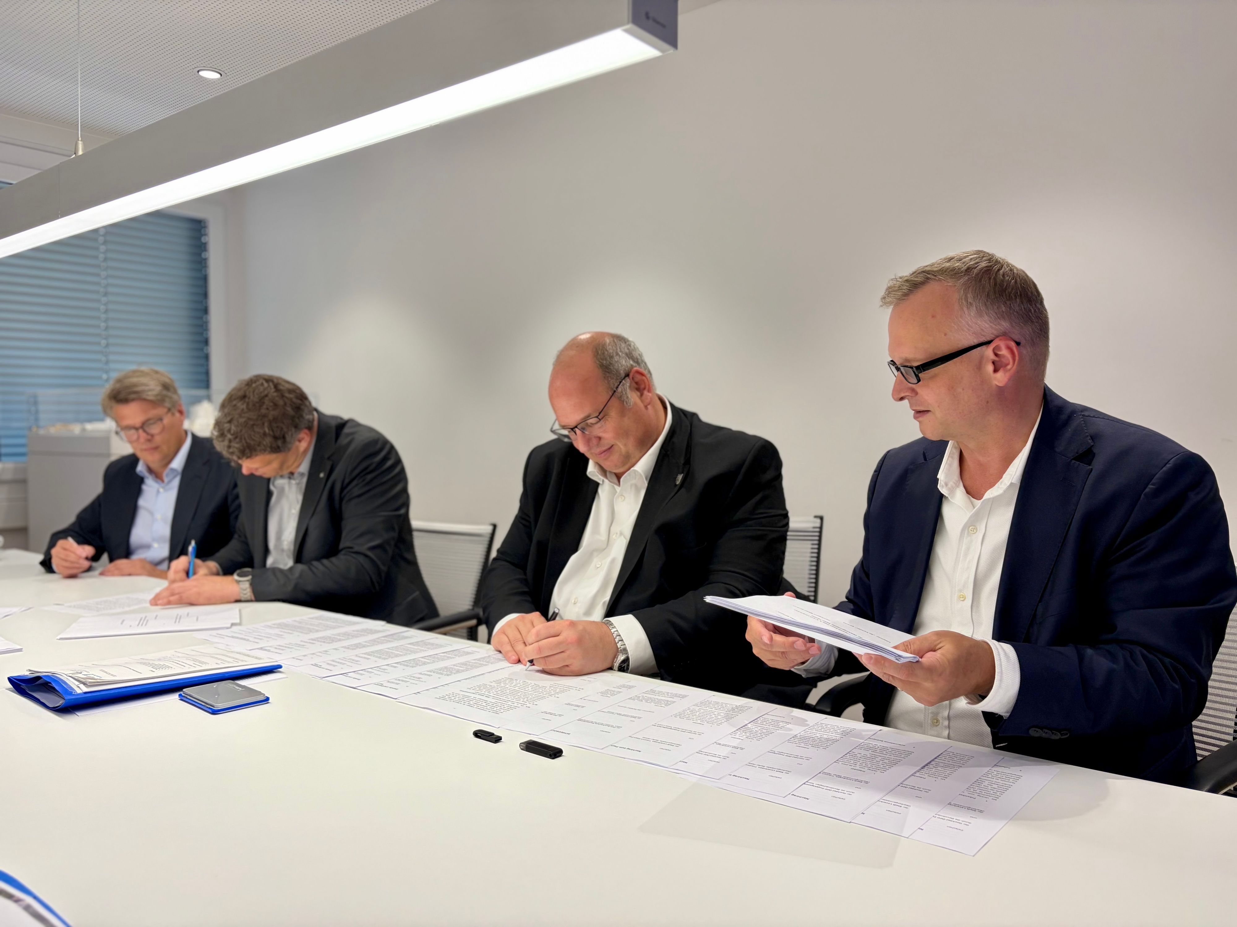 Björn Krischick, Stefan Hebbel, Tobias Lorenz von Hochtief und Christian Alteköster von Spie (von rechts) bei der Vertragsunterzeichnung über den Neubau auf dem Berufsschulcampus an der Bismarckstraße