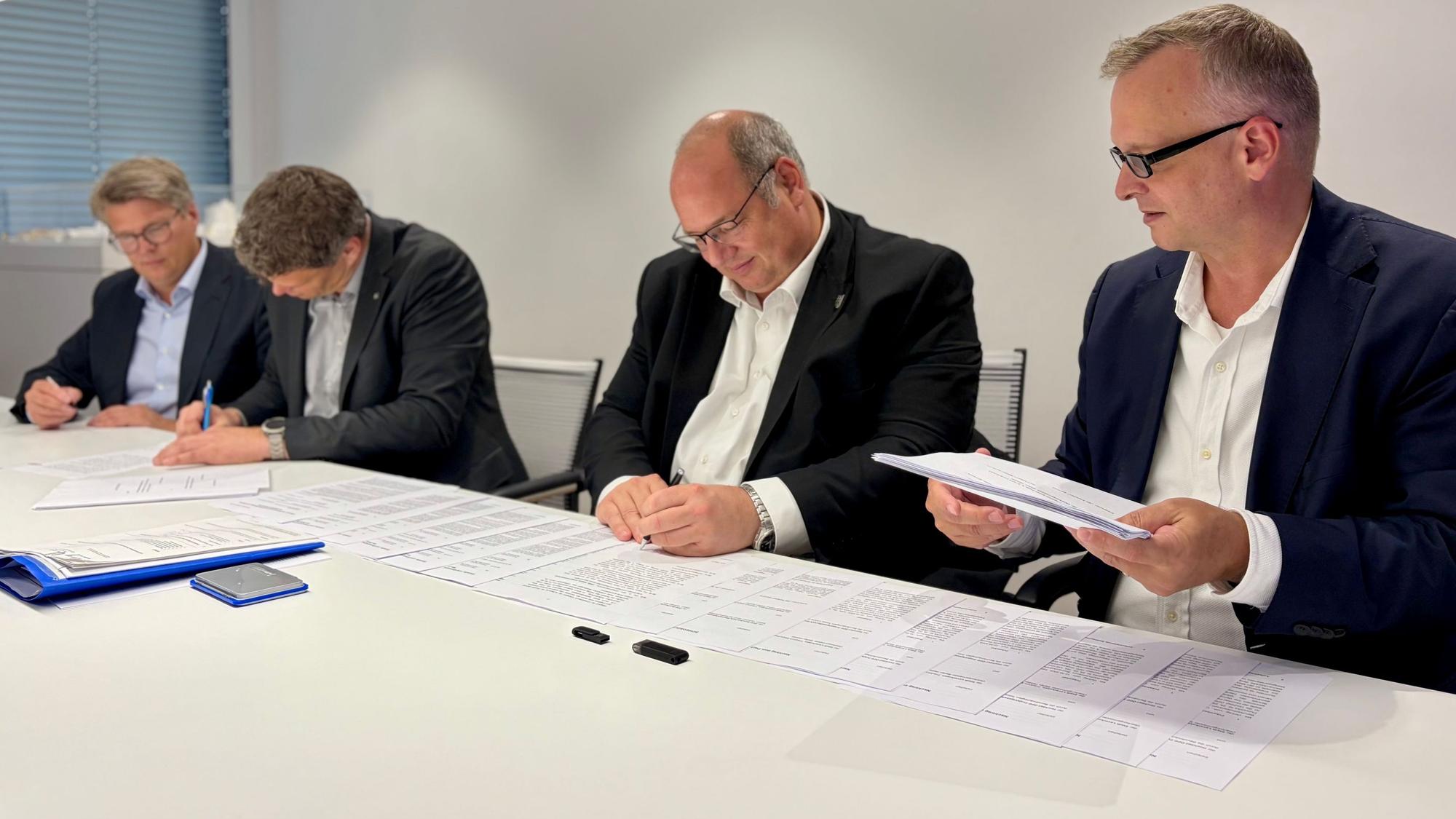 Björn Krischick, Stefan Hebbel, Tobias Lorenz von Hochtief und Christian Alteköster von Spie (von rechts) bei der Vertragsunterzeichnung über den Neubau auf dem Berufsschulcampus an der Bismarckstraße