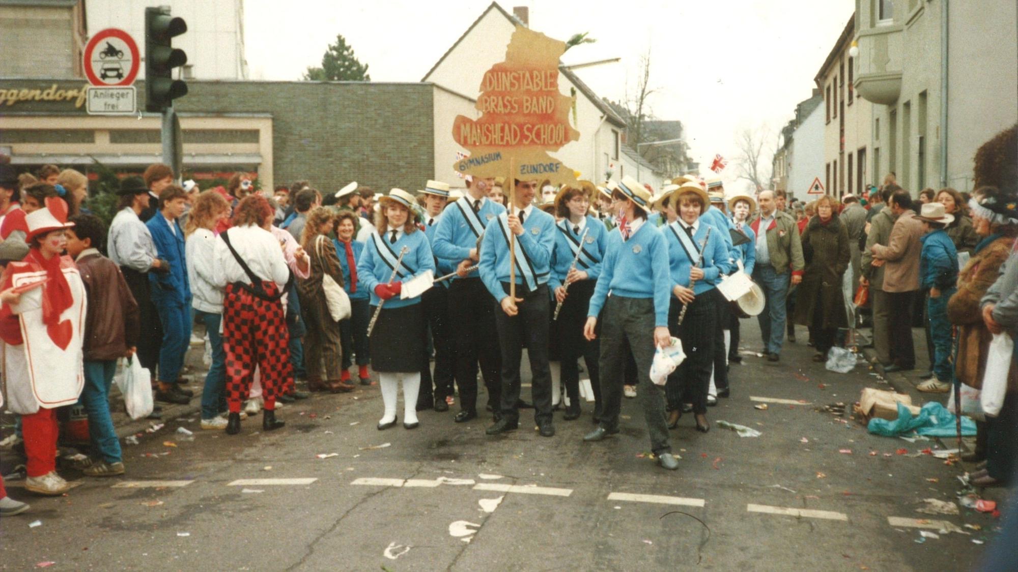 Im Porzer Karnevalszug ging 1987 eine Gruppe aus der englischen Partnerstadt Dunstable mit. Die Schülerinnen und Schüler lernten den rheinischen Frohsinn kennen.