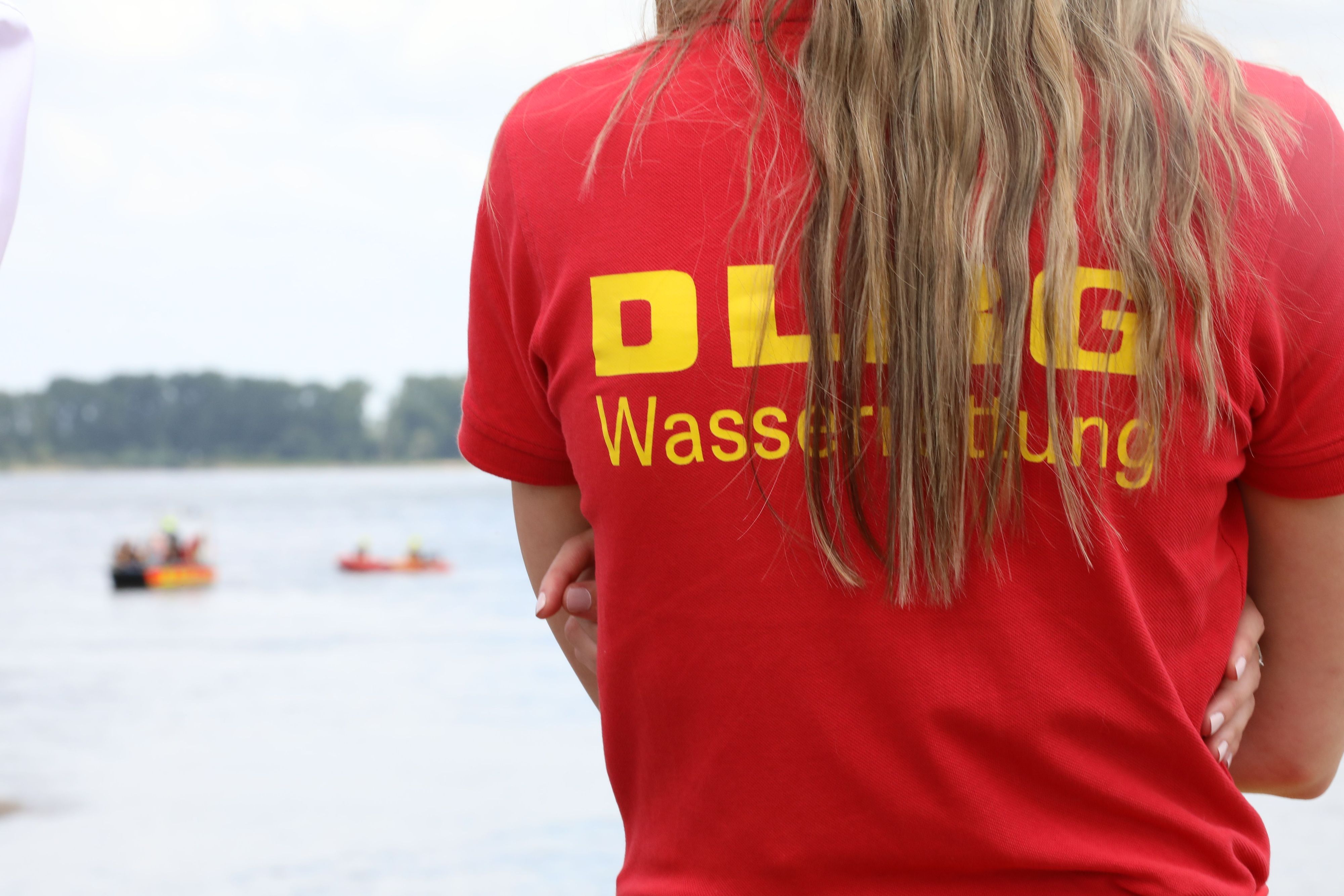 Ein Mitglied der Deutschen-Lebens-Rettungs-Gesellschaft (DLRG) beobachtet eine Rettungsübung auf dem Rhein.