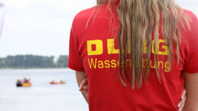 Ein Mitglied der Deutschen-Lebens-Rettungs-Gesellschaft (DLRG) beobachtet eine Rettungsübung auf dem Rhein.