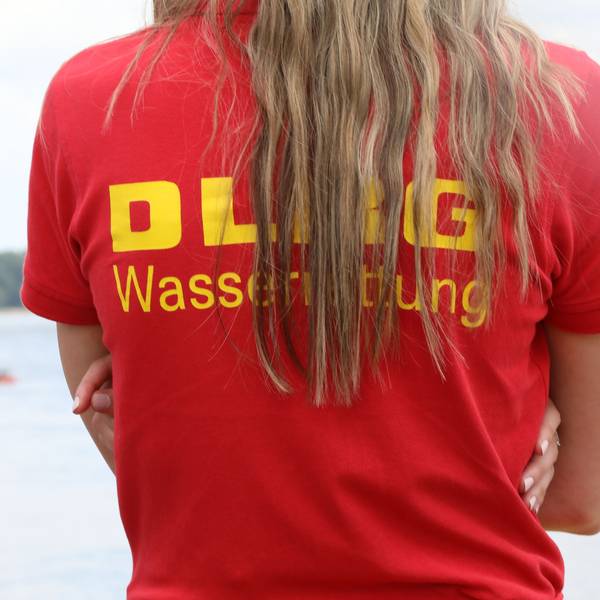 Ein Mitglied der Deutschen-Lebens-Rettungs-Gesellschaft (DLRG) beobachtet eine Rettungsübung auf dem Rhein.