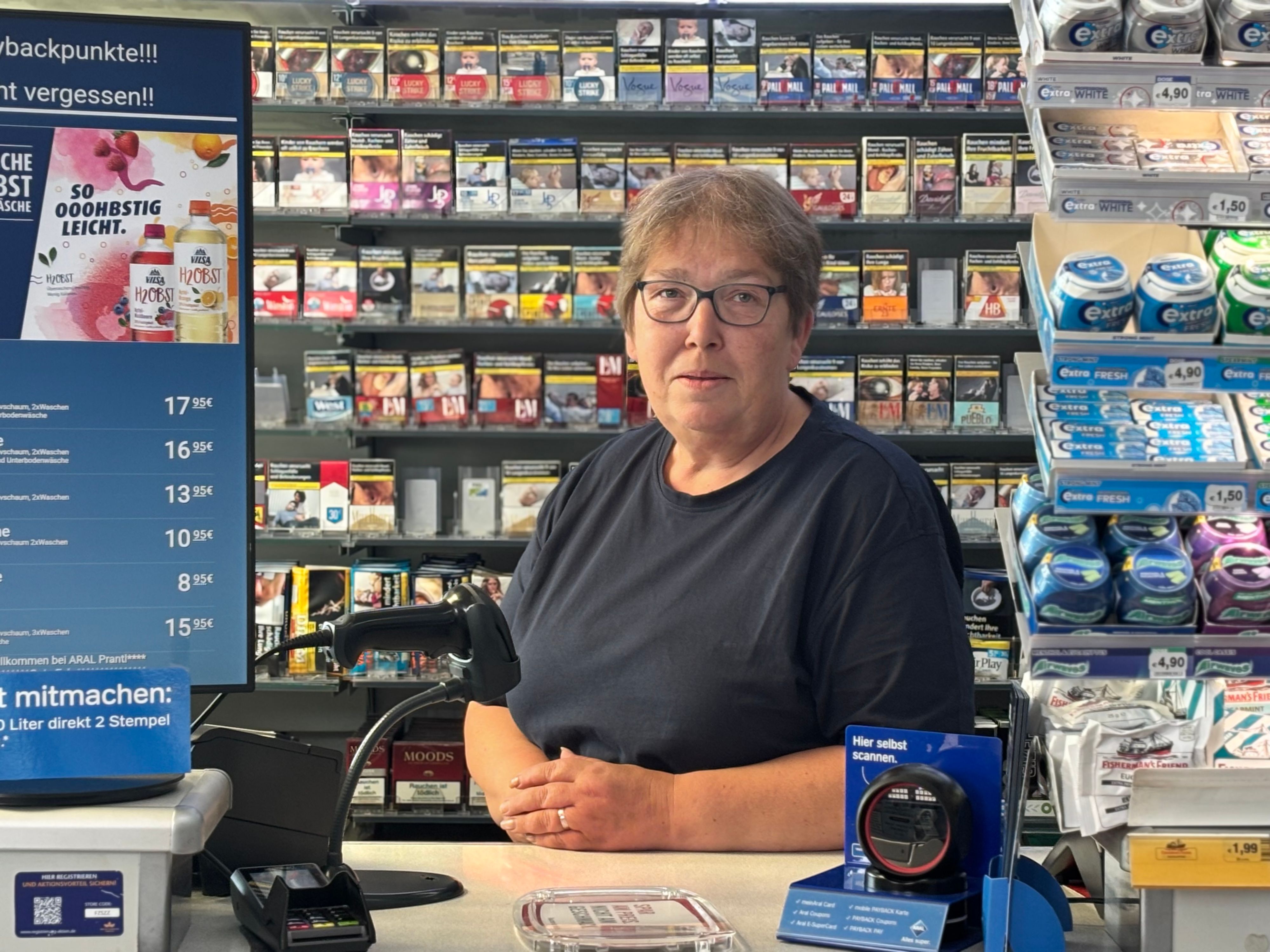 Elke W. steht hinter dem Tresen an der Tankstelle.