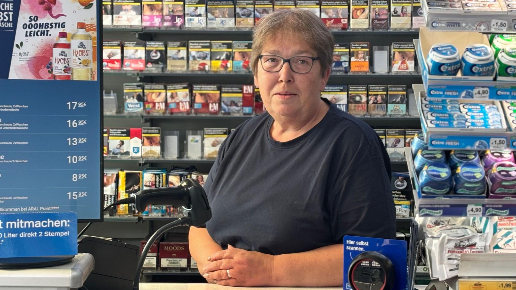 Elke W. steht hinter dem Tresen an der Tankstelle.