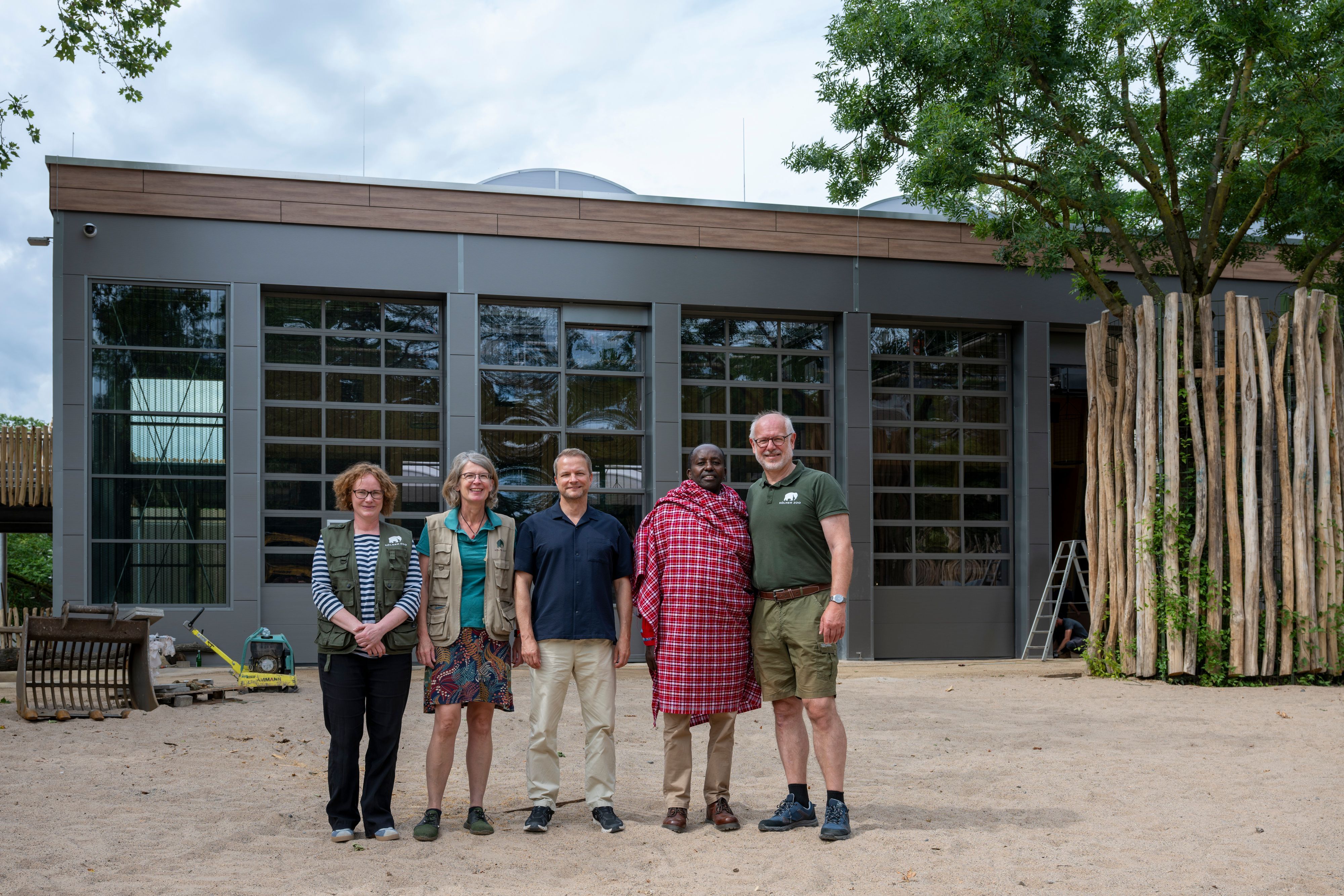 Das Giraffenhaus im Kölner Zoo wurde erneuert und ausgebaut, bald ziehen die Tiere ein. Hier Theo Pagel (r.) mit Rimoine Ole Kararei aus Kenia (2. v. r), Jens Bergmann von chance e. V. (M.), Zoopädagogin Ruth Dickmann und Artenschutz-Kuratorin Johanna Rode-White (l.).
