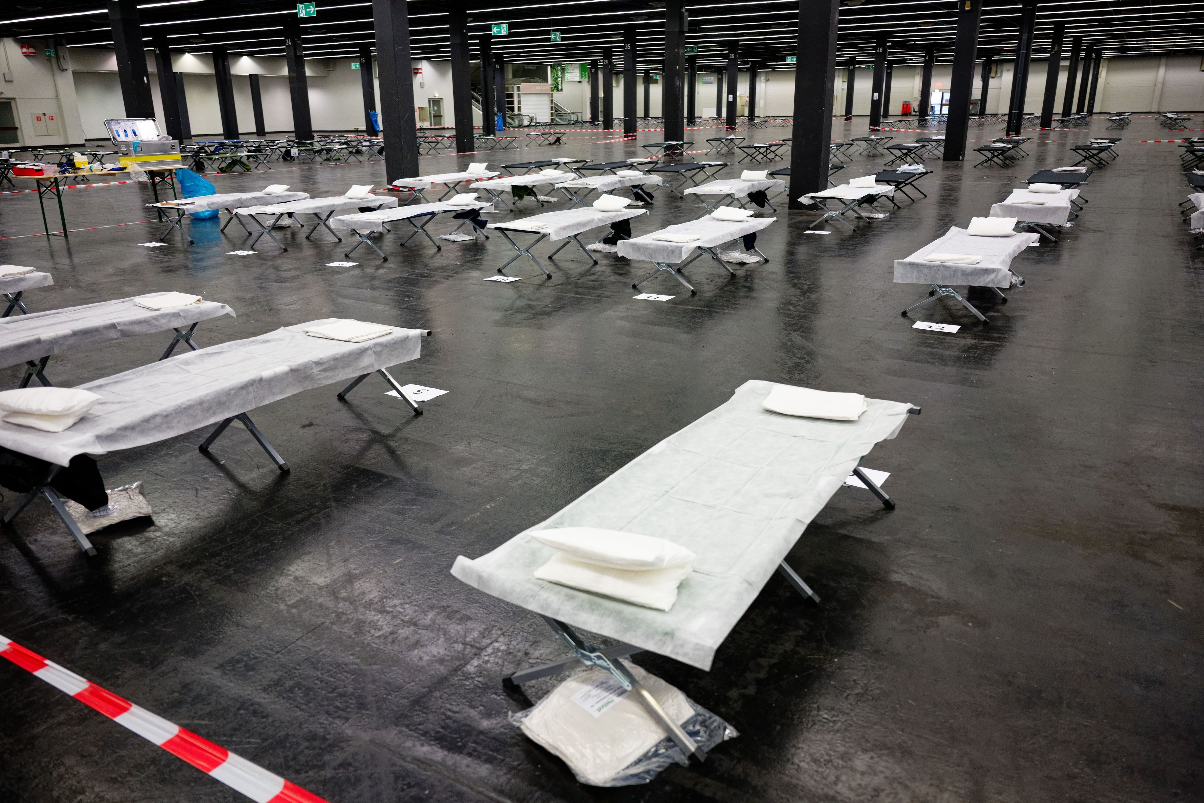 Feldbetten und medizinisches Material stehen im Notfallversorgungszentrum der Feuerwehr in einer gekühlten Messehalle bereit.