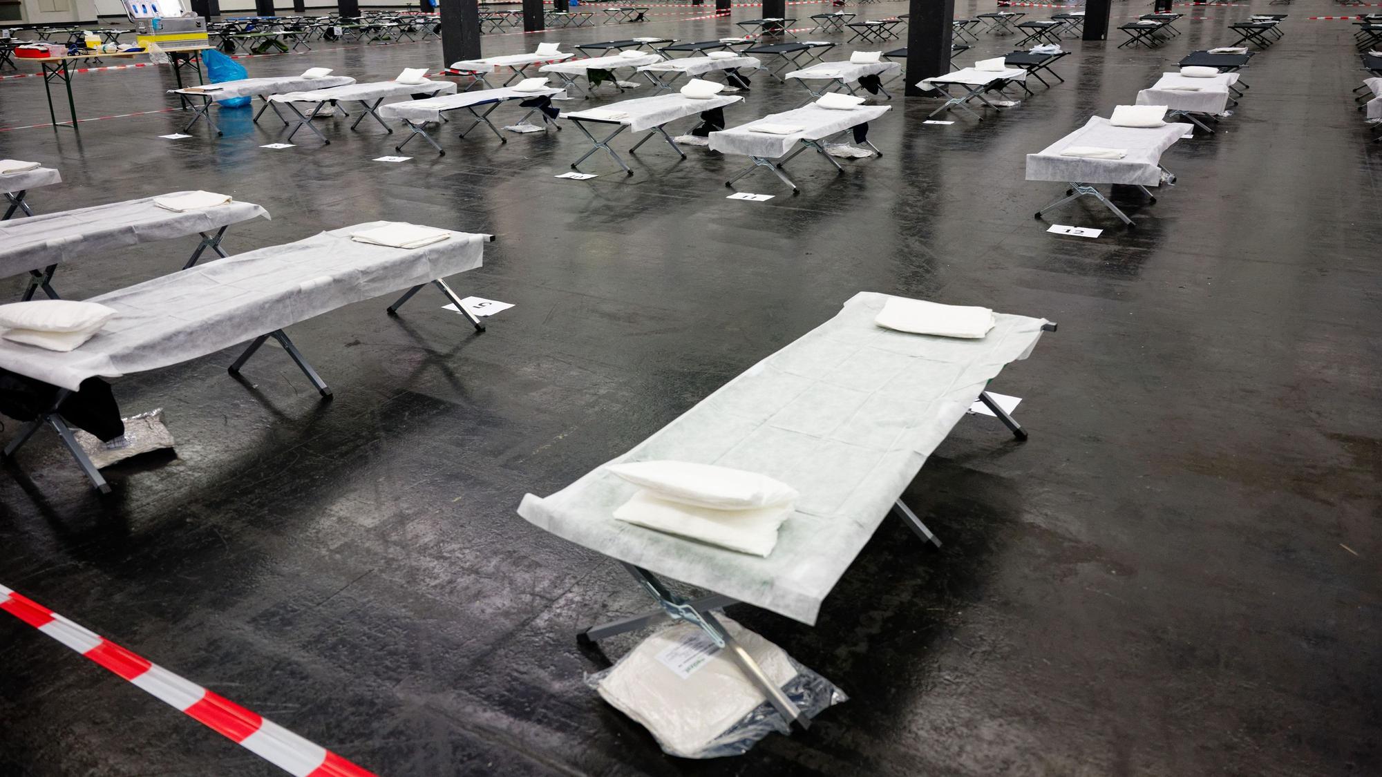 Feldbetten und medizinisches Material stehen im Notfallversorgungszentrum der Feuerwehr in einer gekühlten Messehalle bereit.