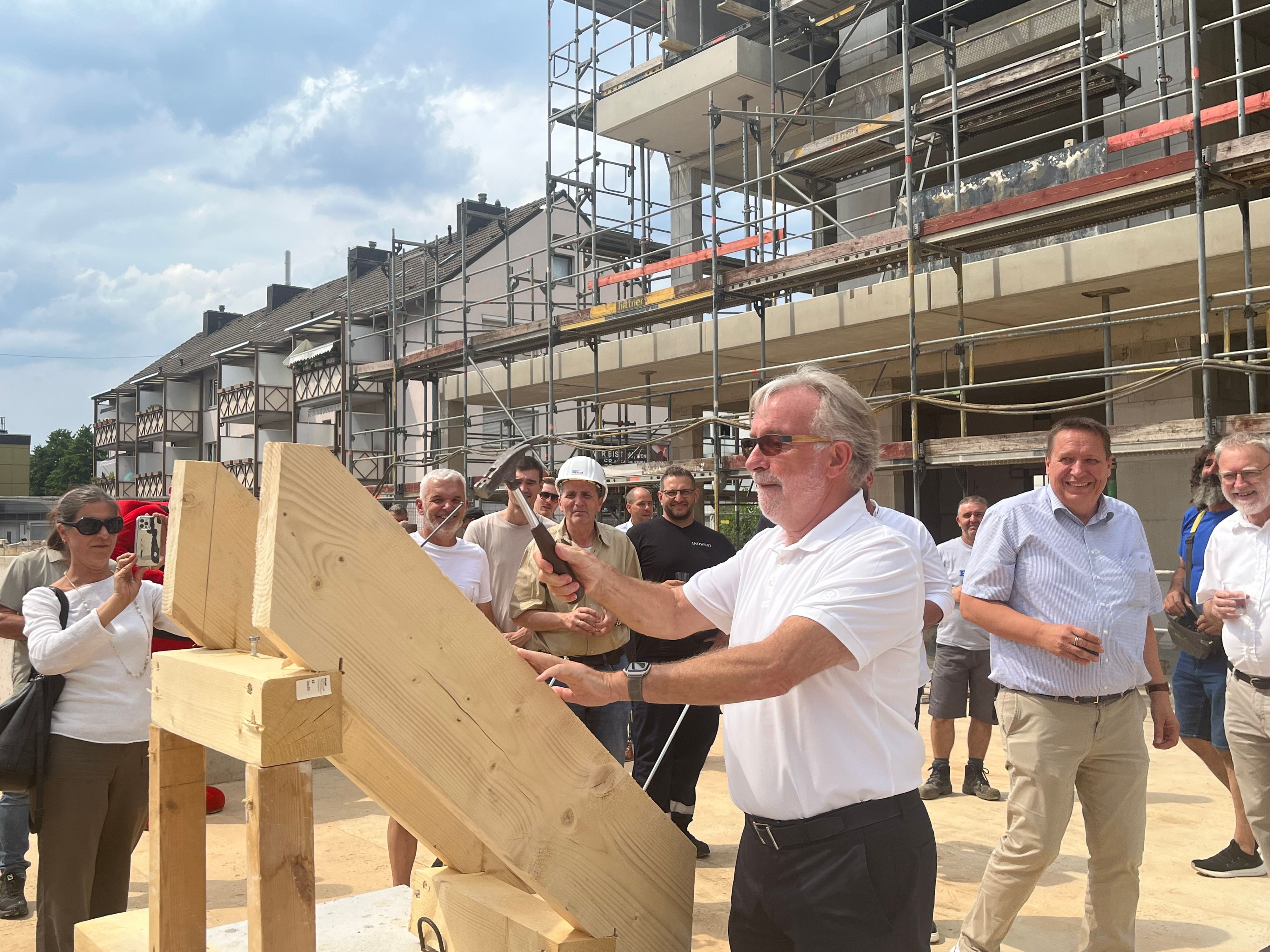 Gernot Paeschke hämmert beim Richtfest den symbolischen letzten Nagel in den Dachstuhl