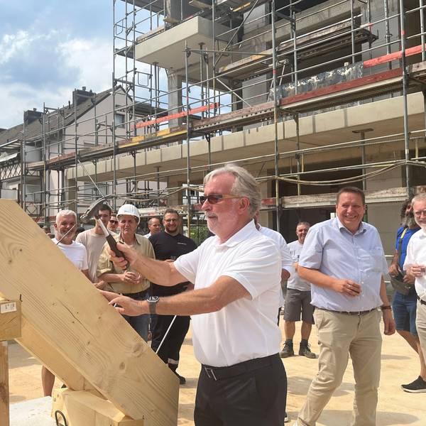 Gernot Paeschke hämmert beim Richtfest den symbolischen letzten Nagel in den Dachstuhl