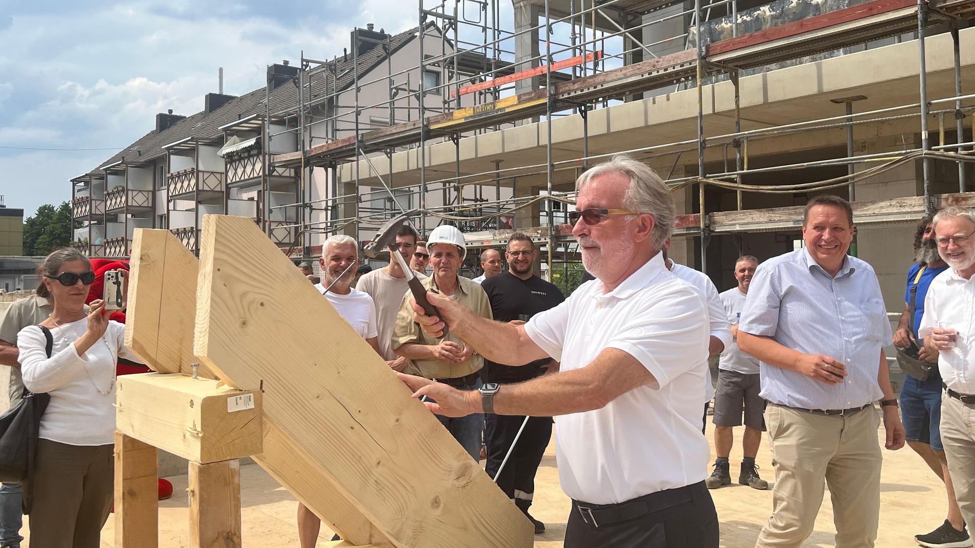 Gernot Paeschke hämmert beim Richtfest den symbolischen letzten Nagel in den Dachstuhl
