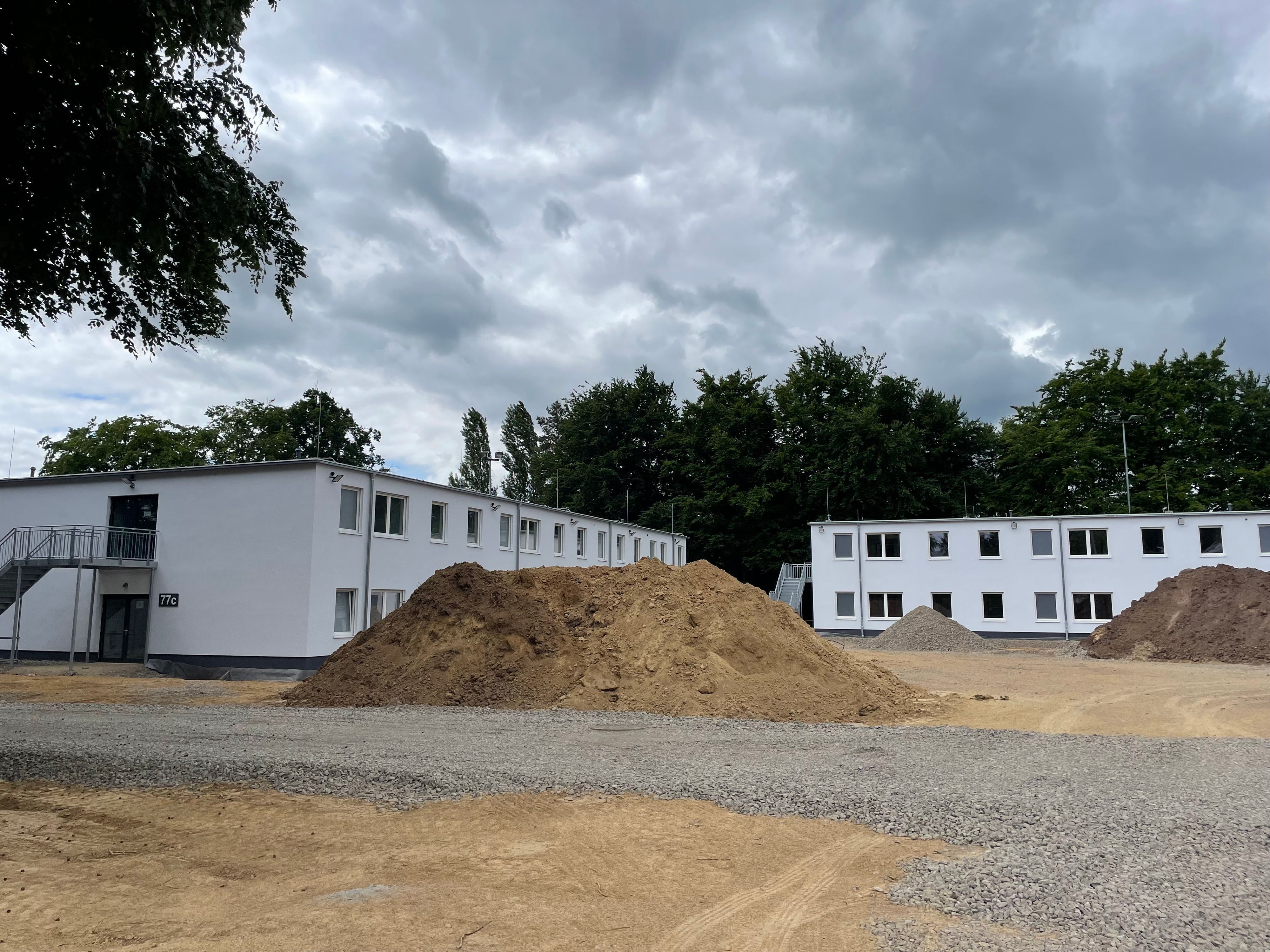 Zwei Gebäudekörper mit weißer Fassade.