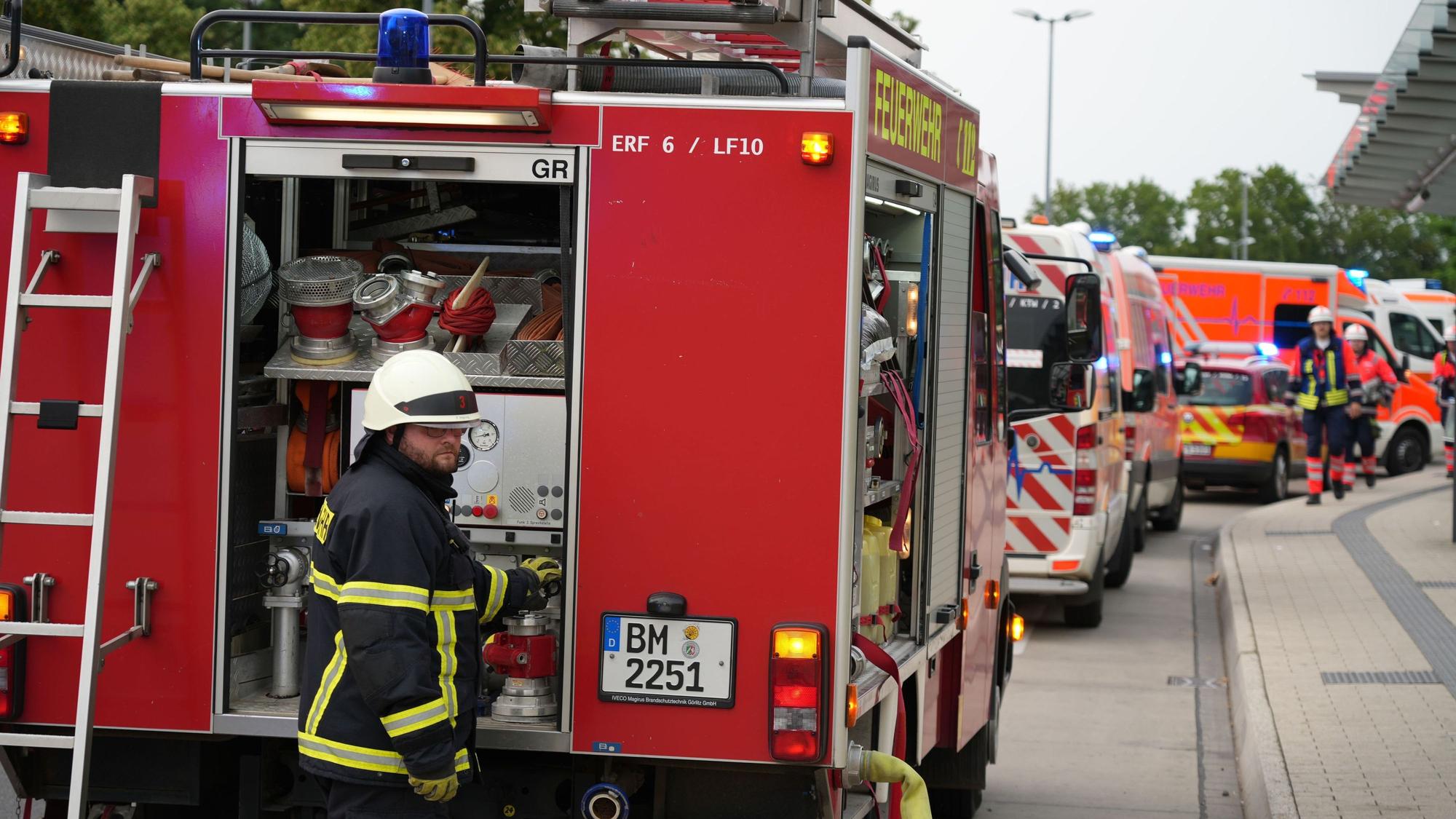 Löschfahrzeuge, Rettungswagen, ein Notarztfahrzeug und Krankentransportfahrzeuge stehen an einer Straße.